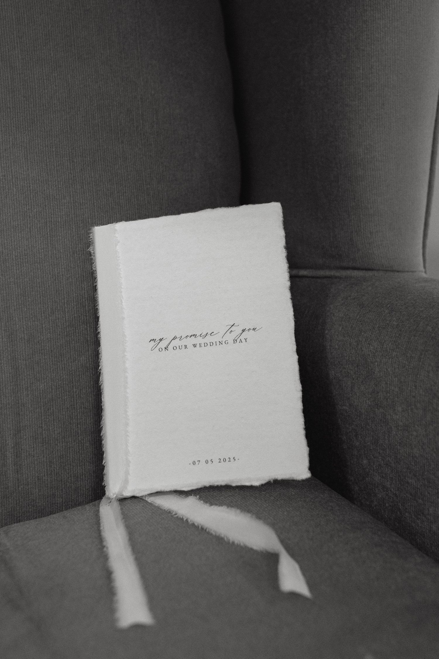 A sequence of four black and white photos showing a small white note card casting shadows on a dark chair or sofa.