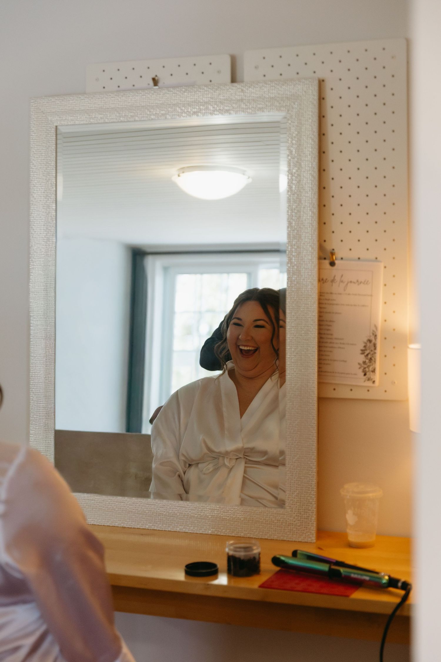 A series of mirror reflections in a bathroom showing someone in a white robe getting ready.