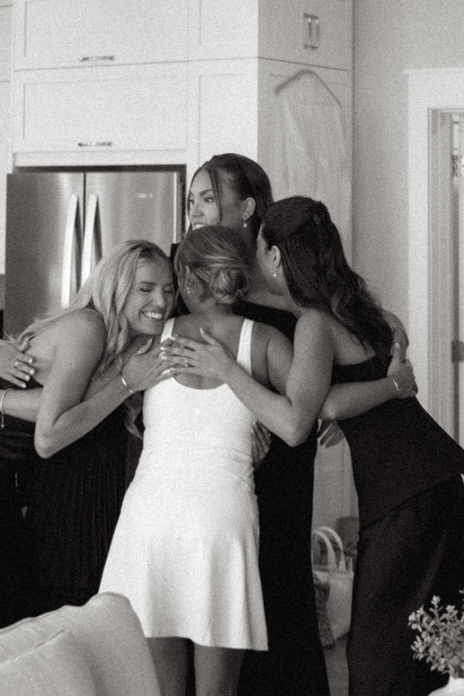 A black and white photo sequence shows a bride and bridesmaid sharing an emotional embrace before a wedding ceremony.