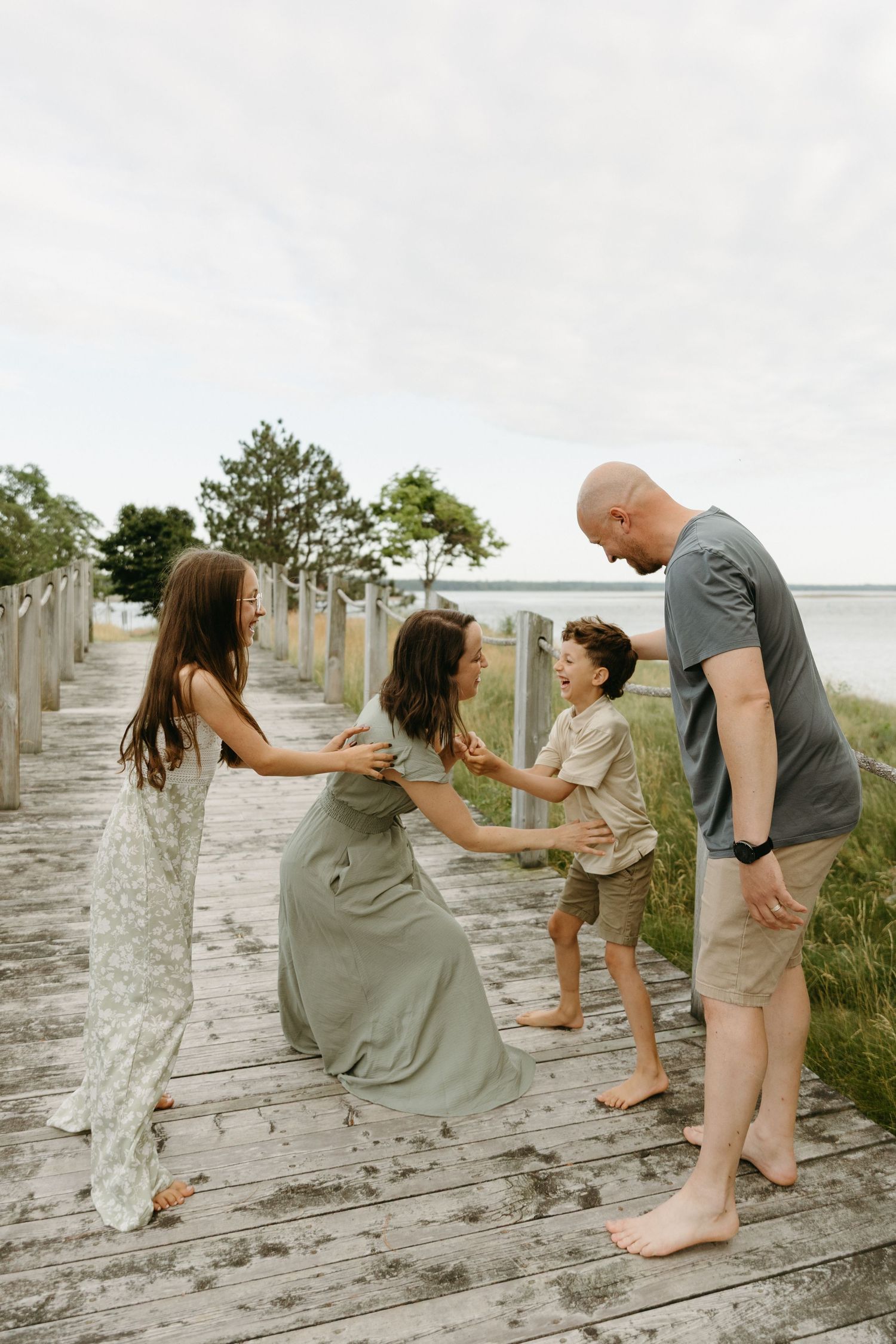 A sequence of photos showing a couple playfully interacting and dancing on a weathered wooden boardwalk by the beach.