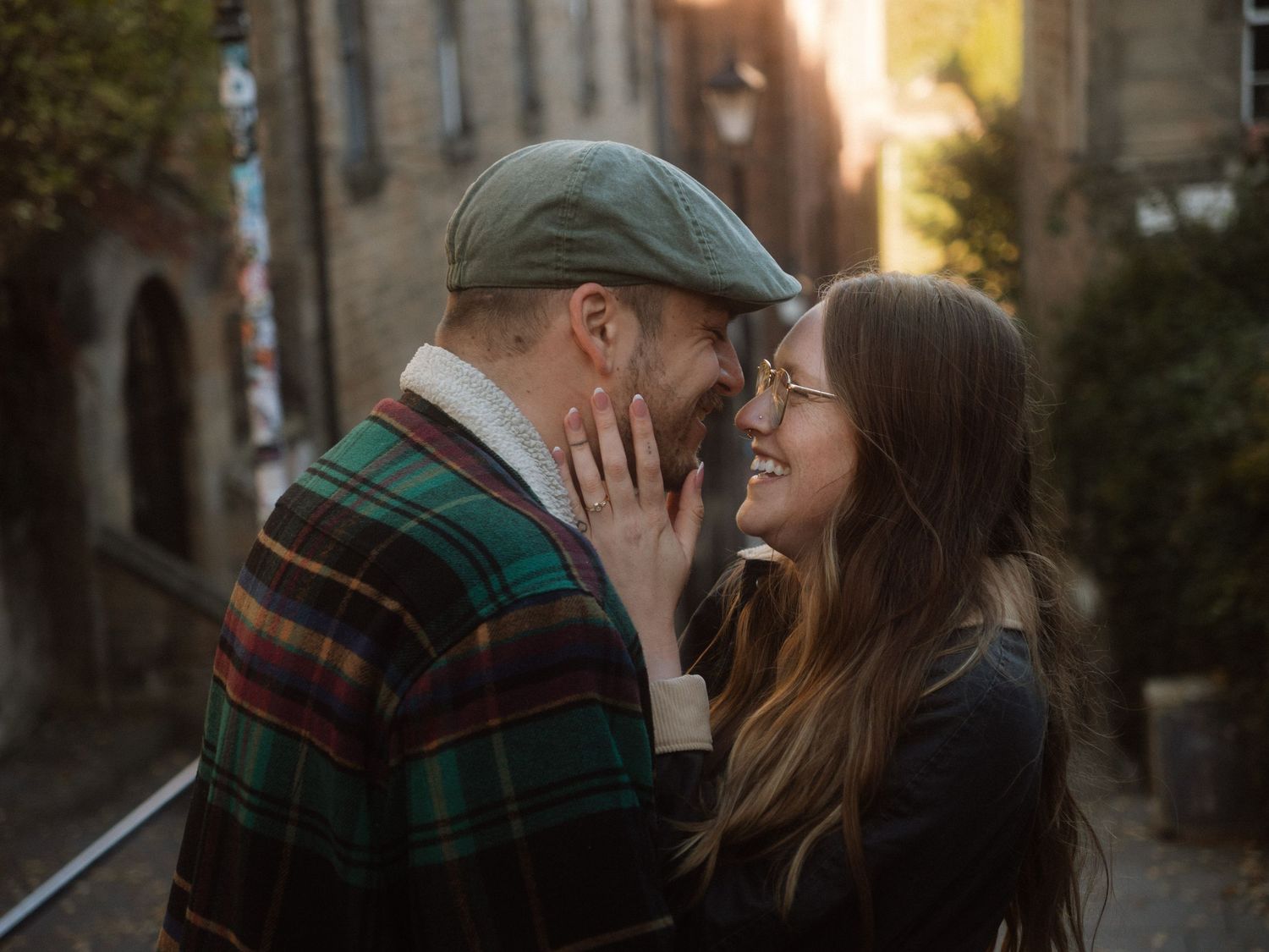 Romantic couple sharing tender moments in a series of outdoor photos against stone buildings.