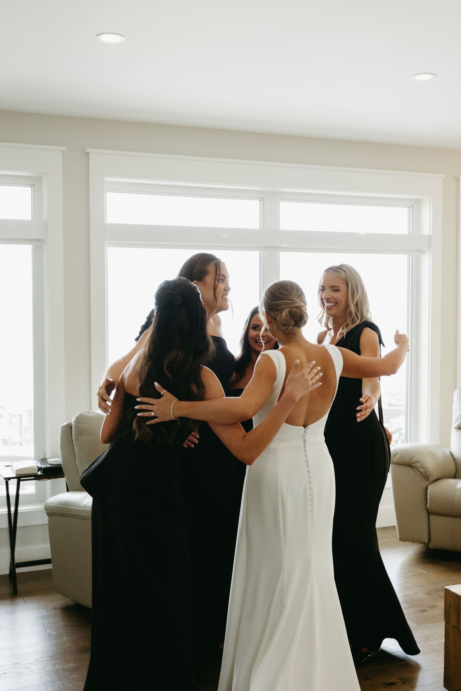 A sequence of photos showing emotional embraces between people in formal attire in a bright modern room.