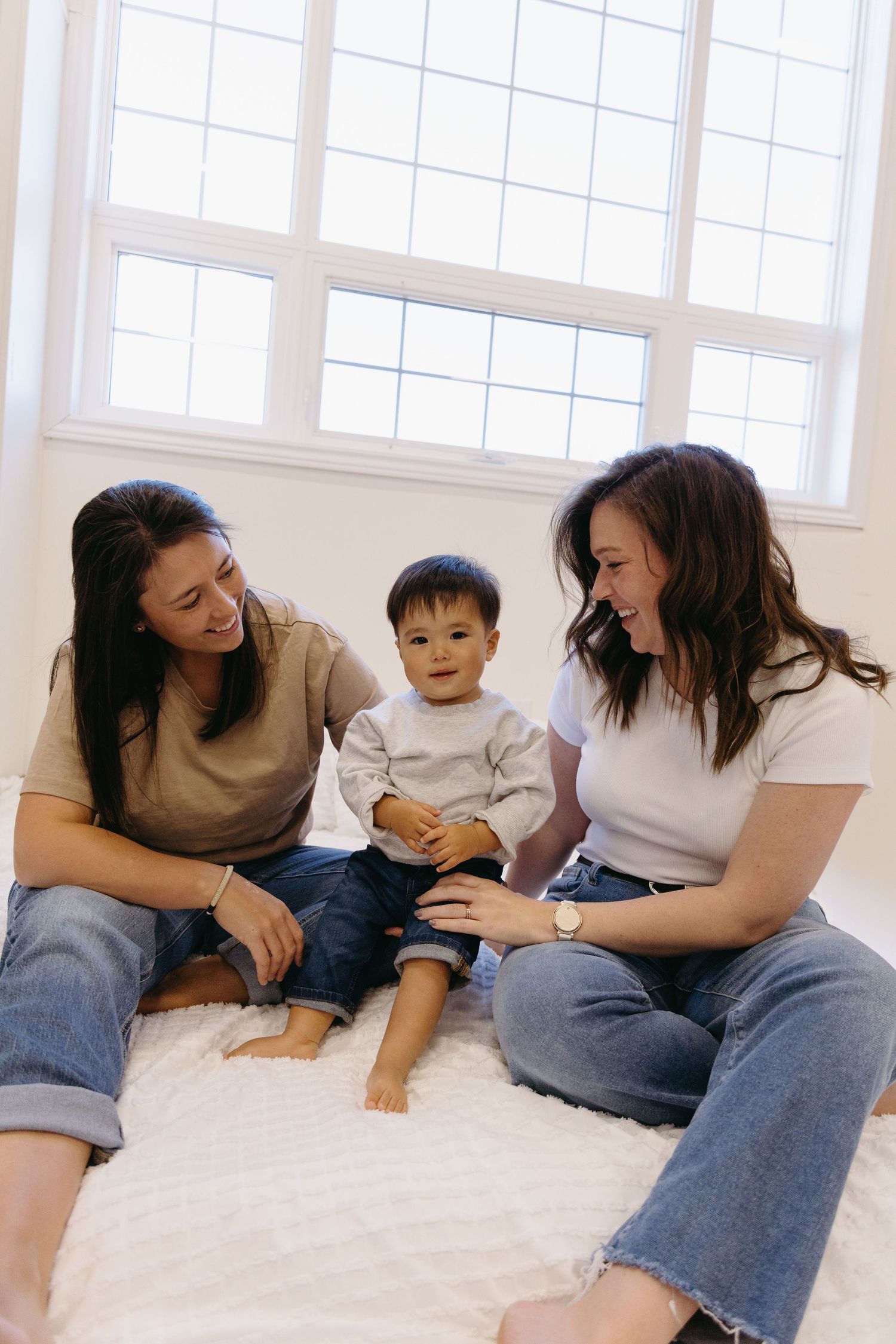 A series of tender moments between parent and child playing together on a white surface.