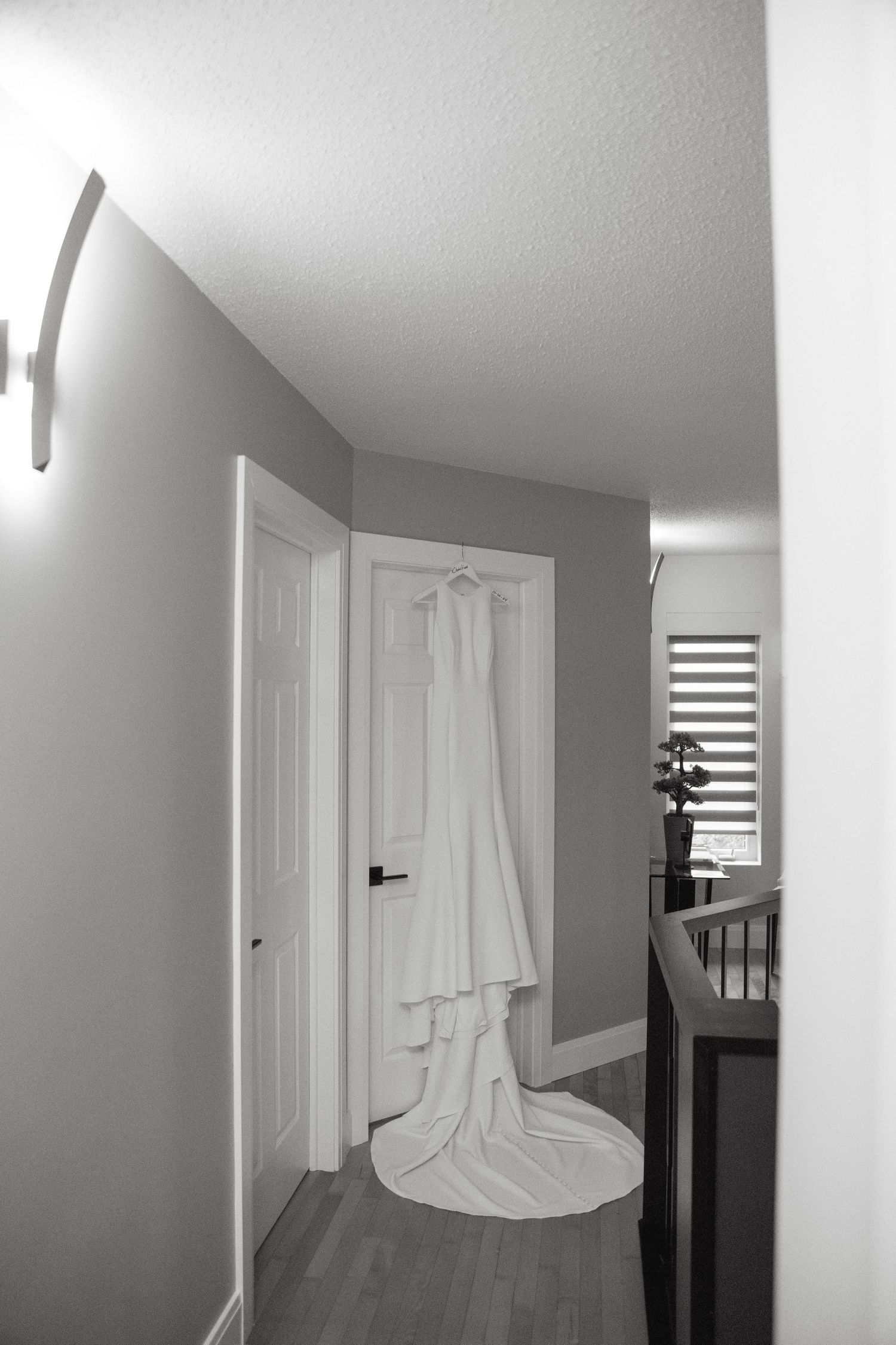A white sheet or curtain appears to be floating mysteriously in a modern hallway with gray walls and wooden floors.