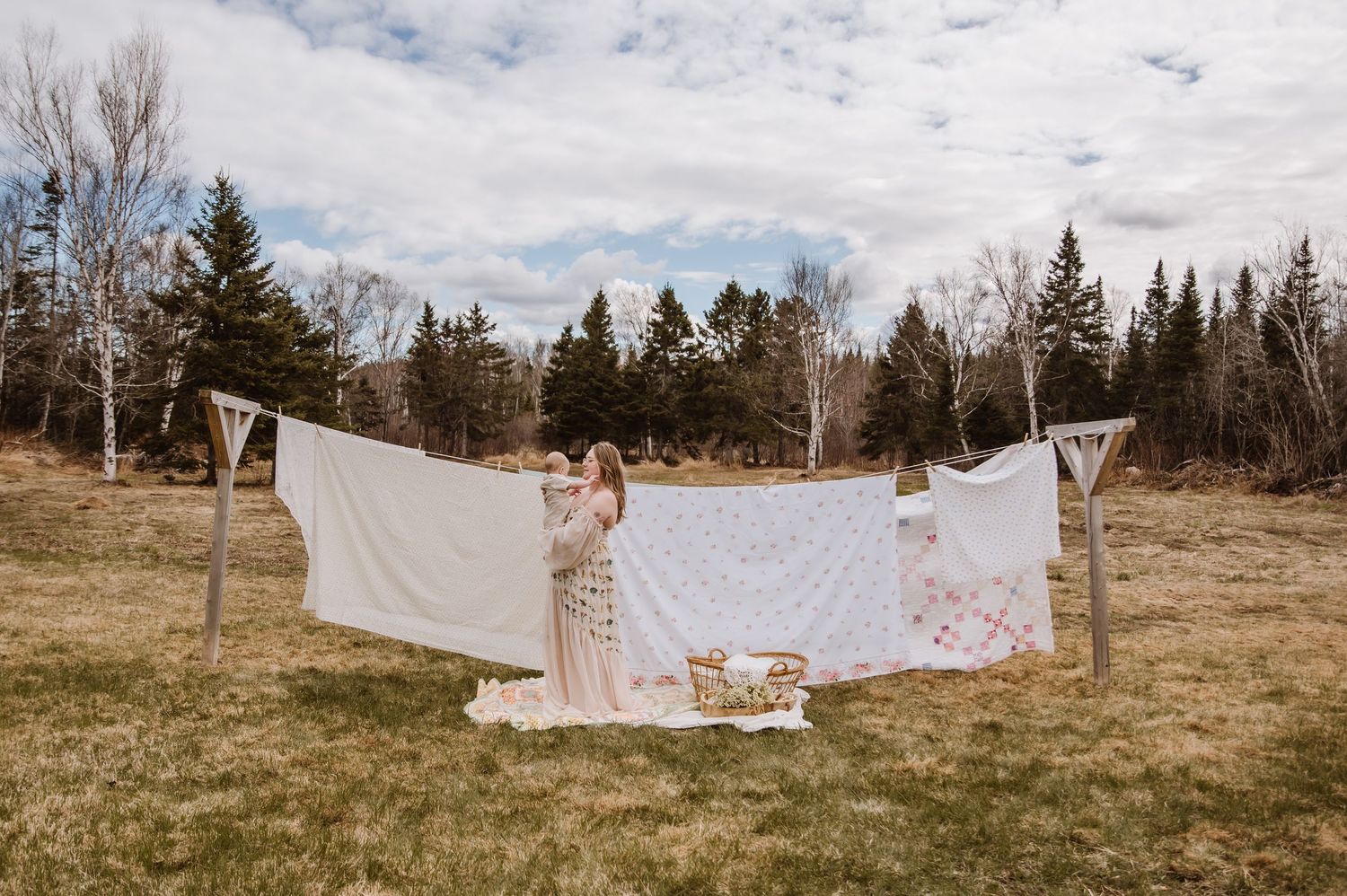 A series of white sheets and linens hanging on clotheslines outdoors against an autumn landscape.