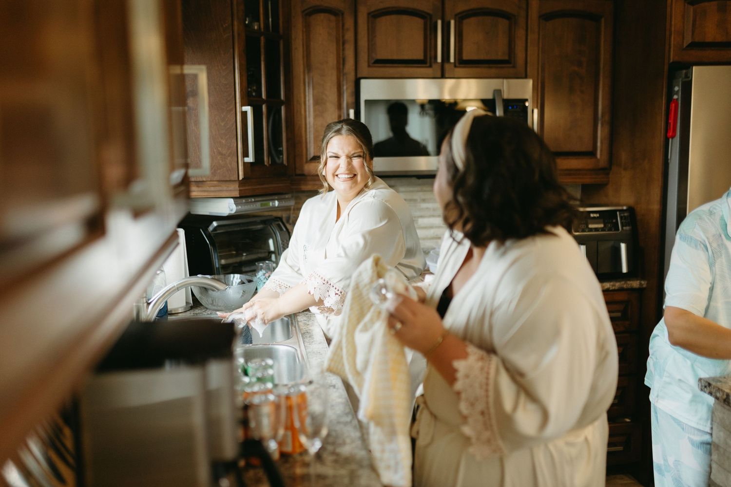 A bride in a white wedding dress shares joyful moments with loved ones in an elegant indoor setting.