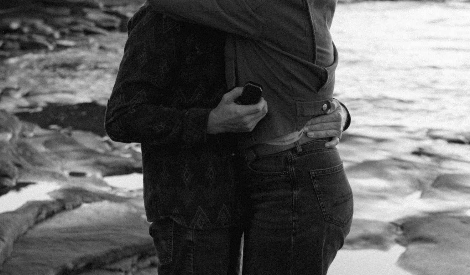 Black and white photo sequence showing a couple embracing on a beach with waves crashing behind them.