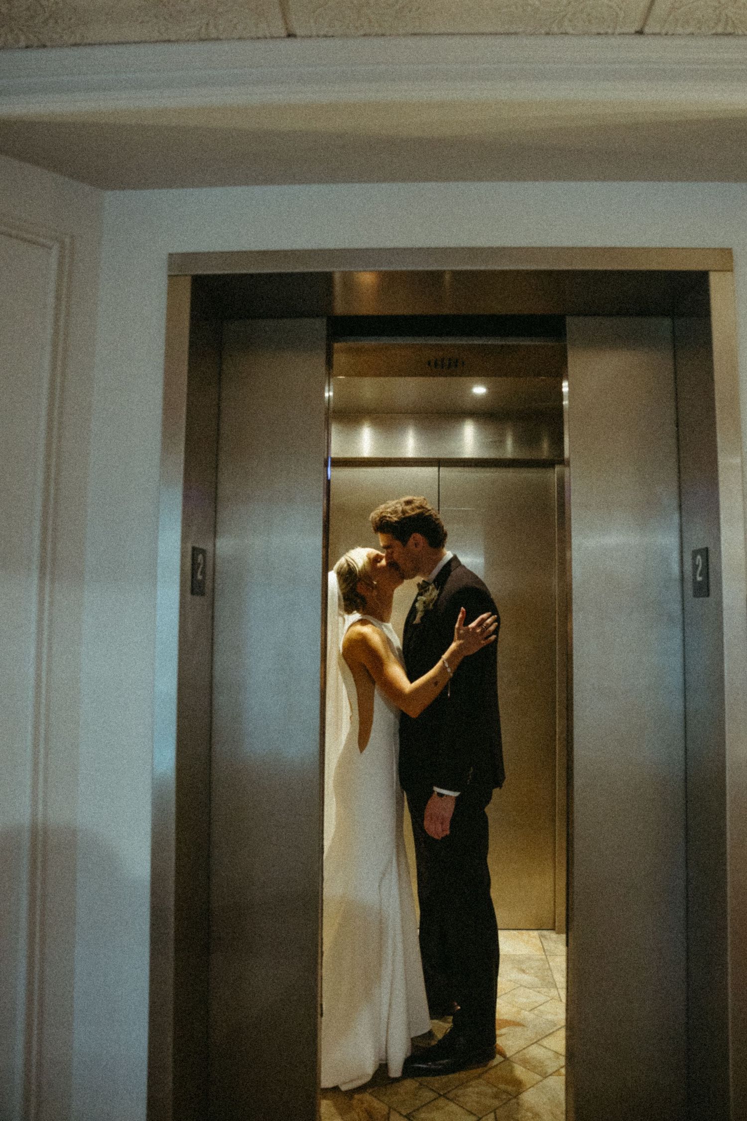 A sequence of photos showing a couple in wedding attire sharing intimate moments near an elevator.