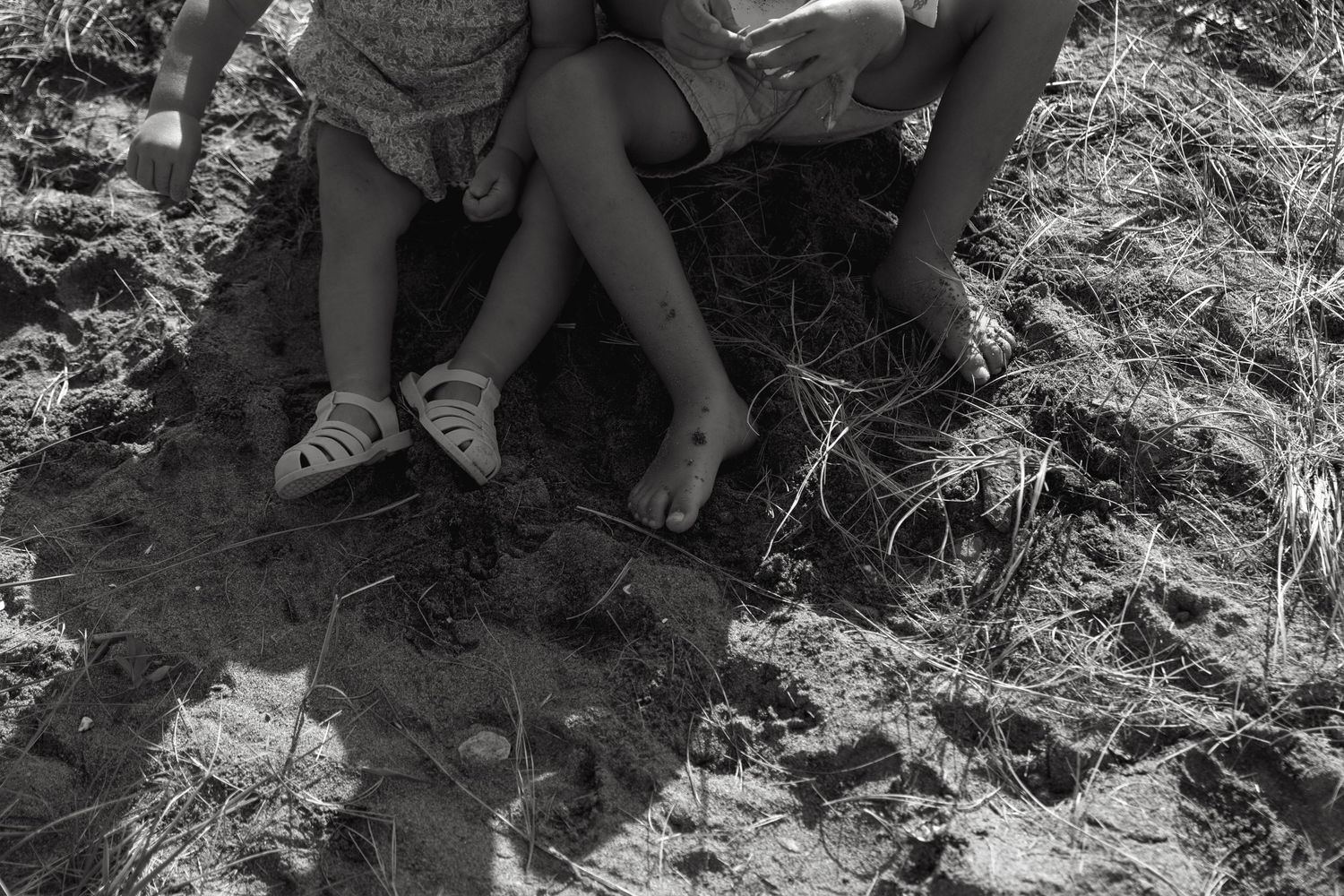 Couple sitting together on grassy ground in casual outdoor setting.