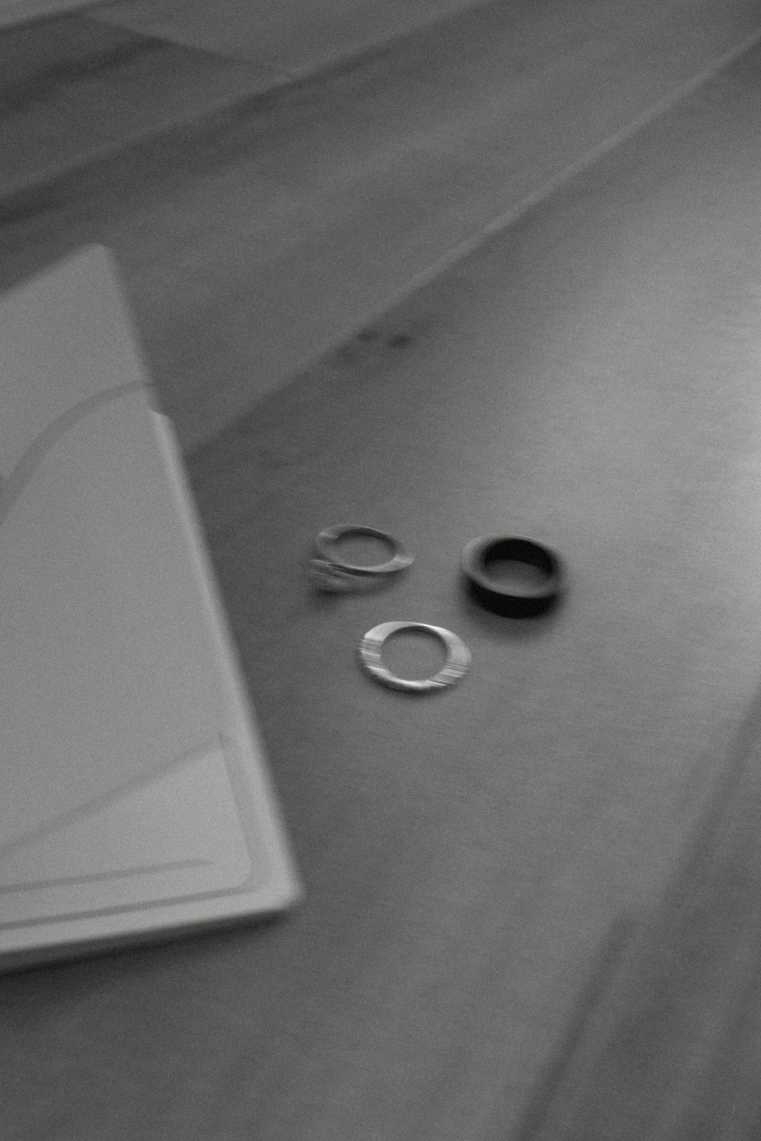 Close-up sequence of rings on a wooden floor in black and white.