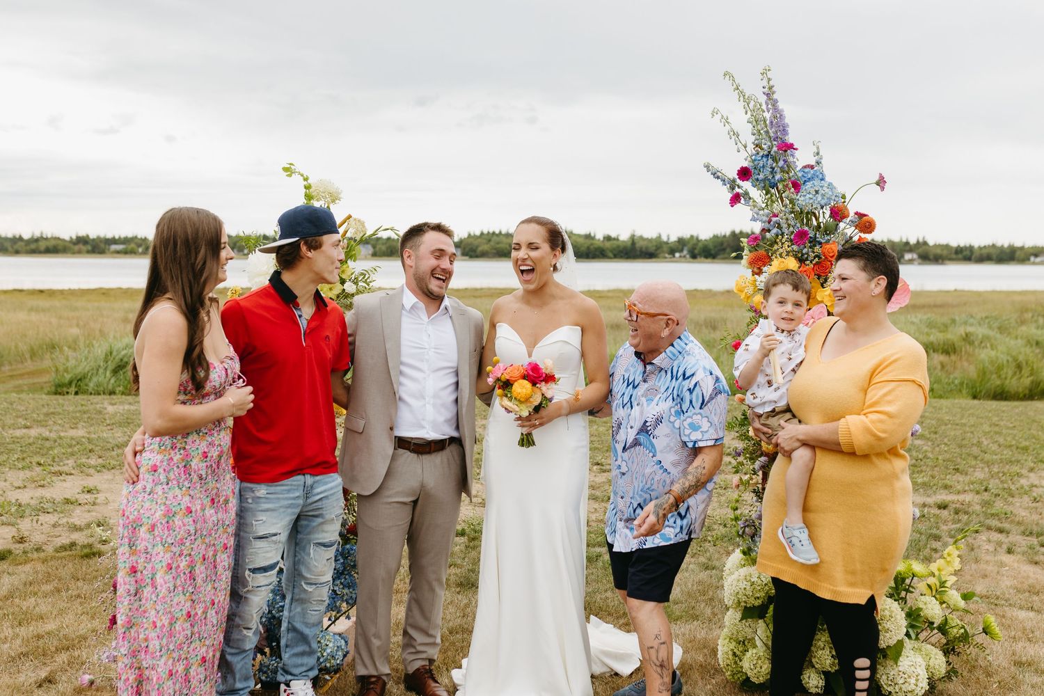 Group of people standing outdoors in casual attire sharing joyful moments during a special celebration.