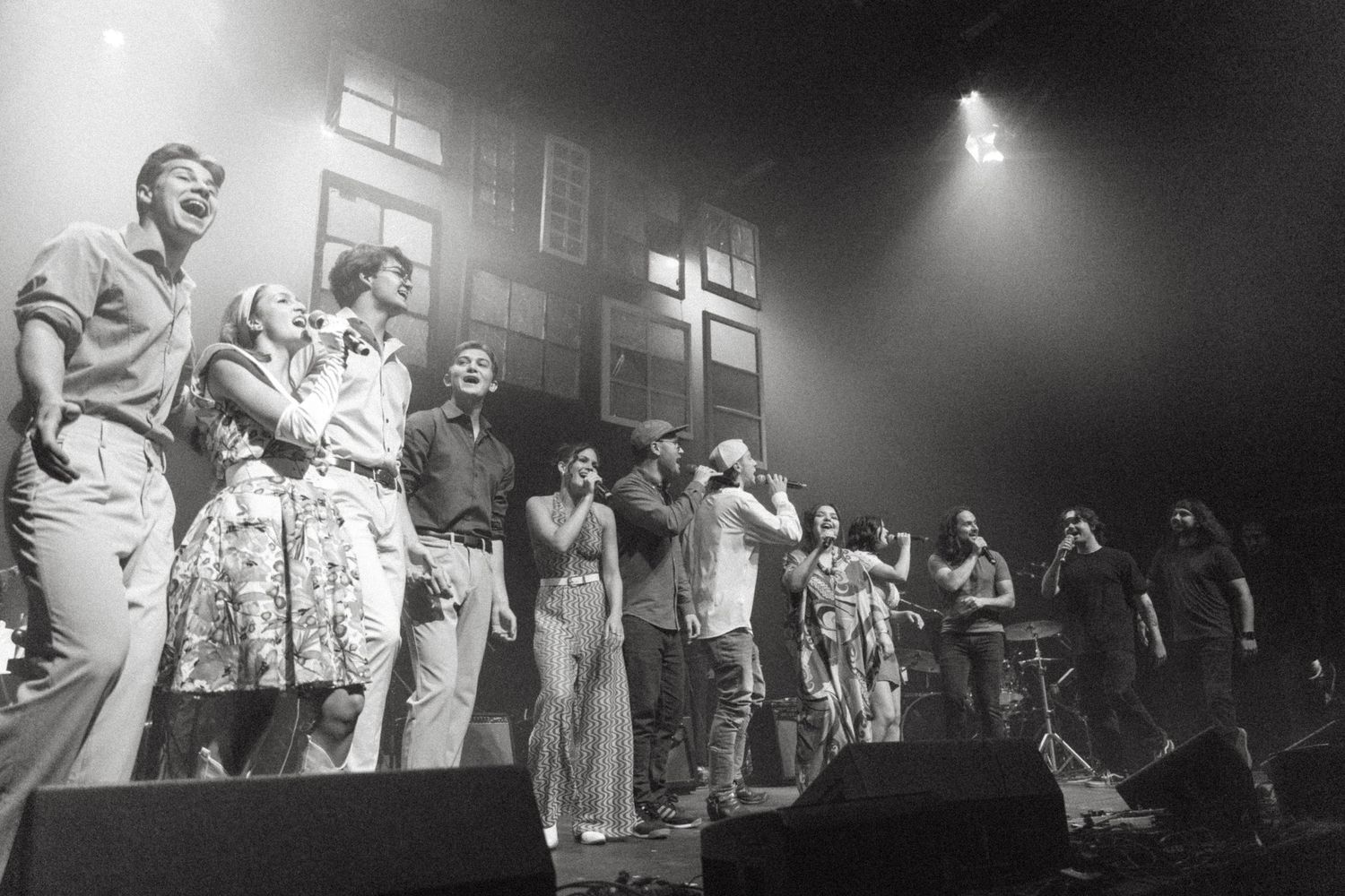 Black and white photo montage shows performers dancing and singing on stage during an energetic concert performance.