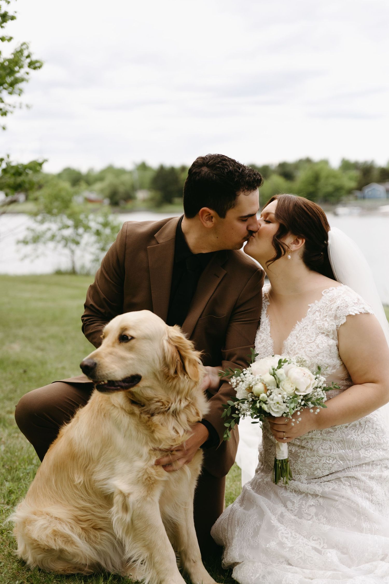 A couple in wedding attire shares romantic moments outdoors with their golden retriever dog in a series of photos.