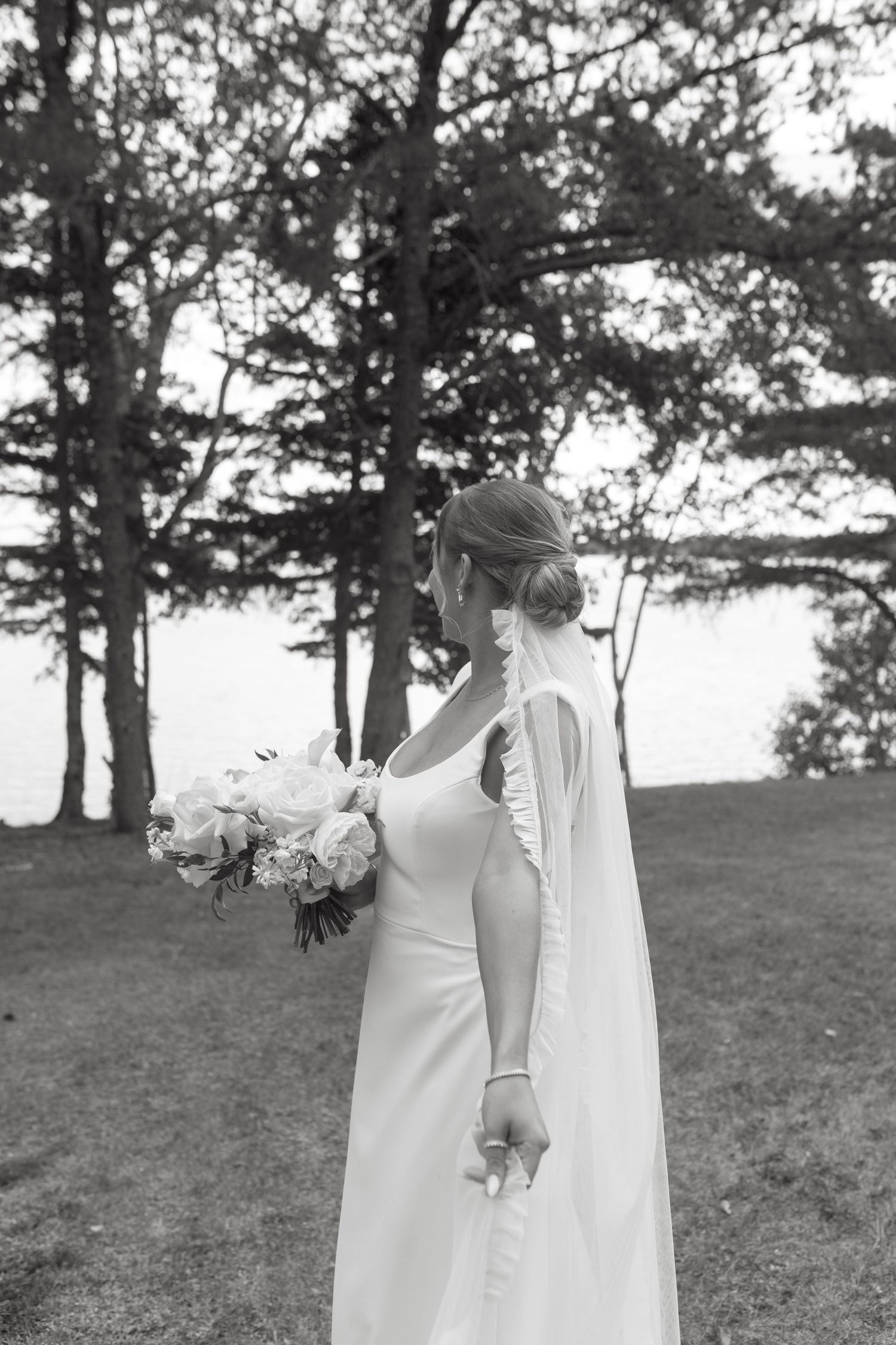 A series of black and white wedding photos showing a bride in a white dress walking through a scenic outdoor setting.