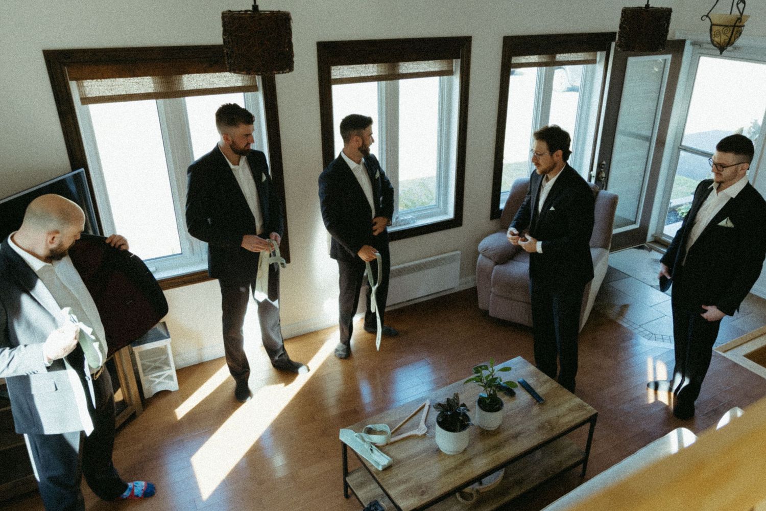 Business professionals gather in a bright modern office space for a meeting near large windows overlooking the city.