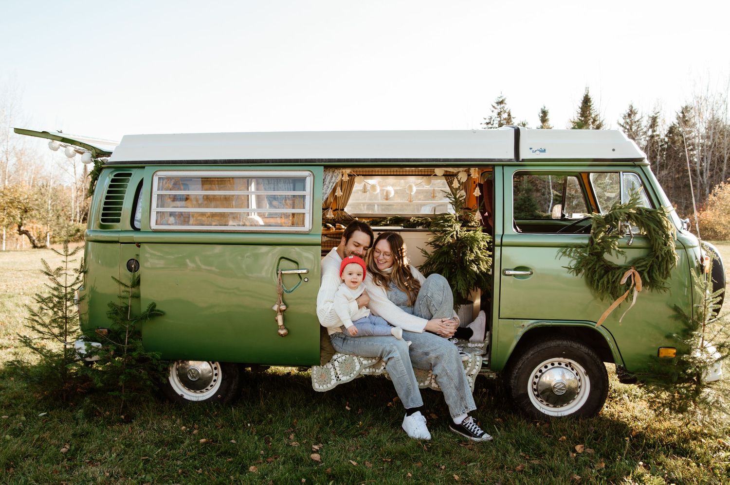 A vintage green Volkswagen van parked in a rustic outdoor setting during autumn.