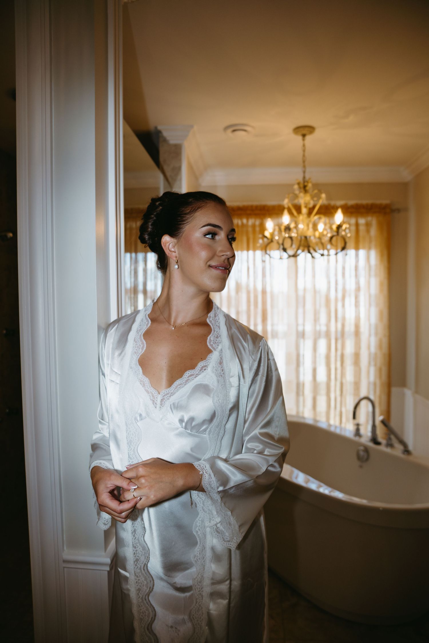 A series of artistic bridal preparation photos showing someone in a white silk robe against warm lighting and elegant decor.