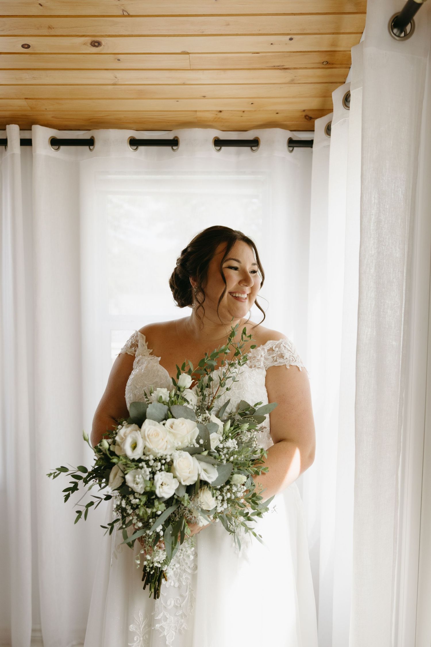 A sequence showing a person in a white dress with a beautiful floral bouquet against a bright window.