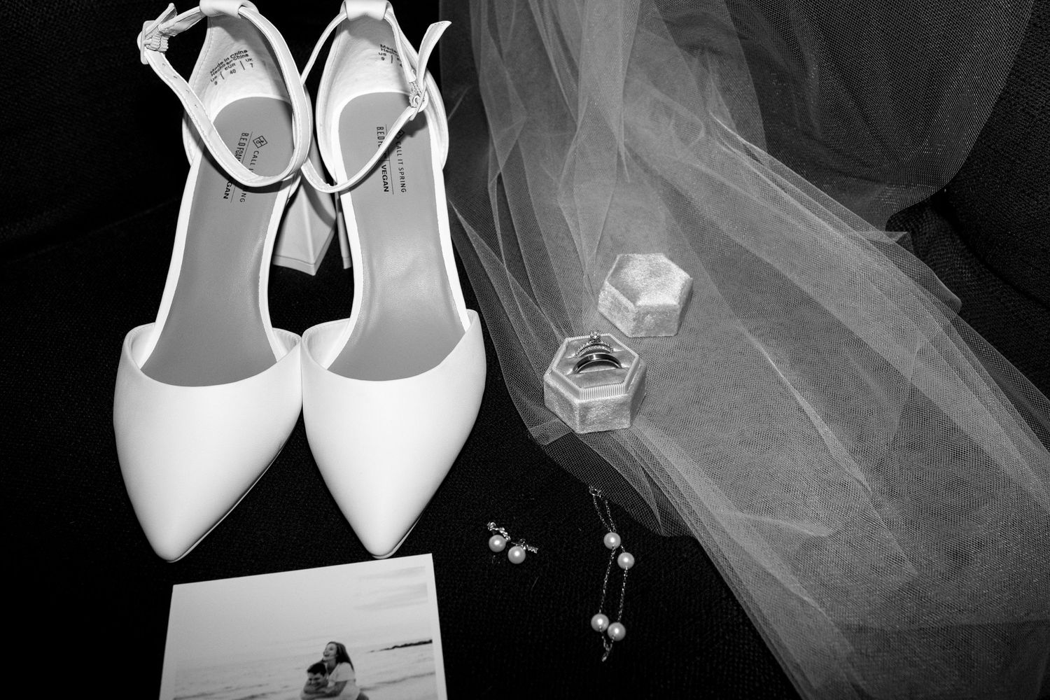A collection of white bridal shoes and veils arranged in a repeating pattern against a dark background.