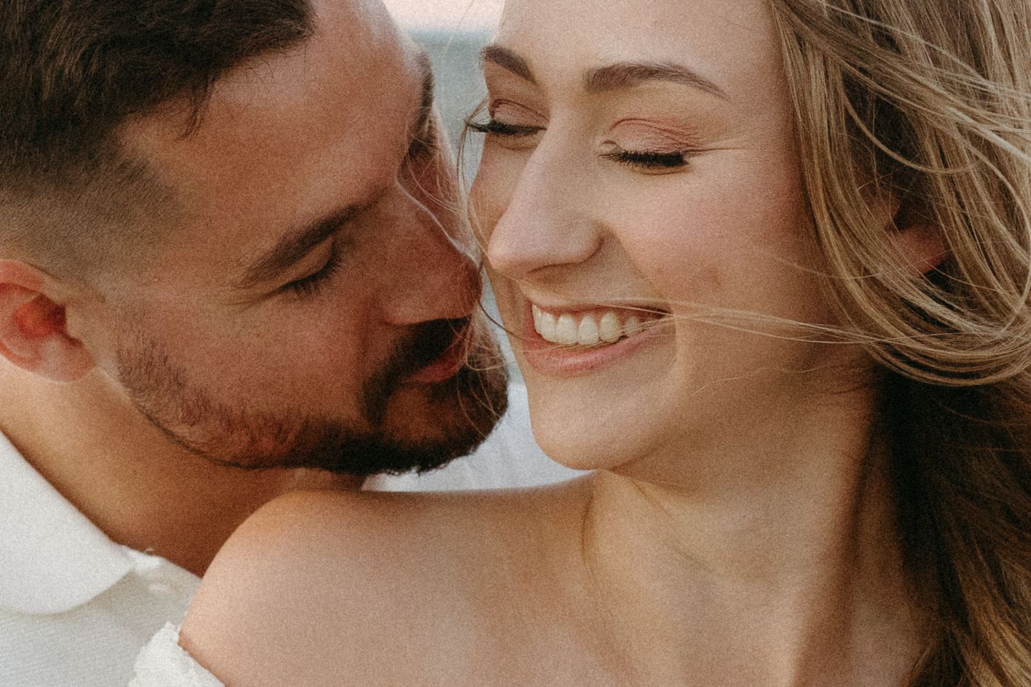 A close-up intimate moment captured between a couple at the beach.