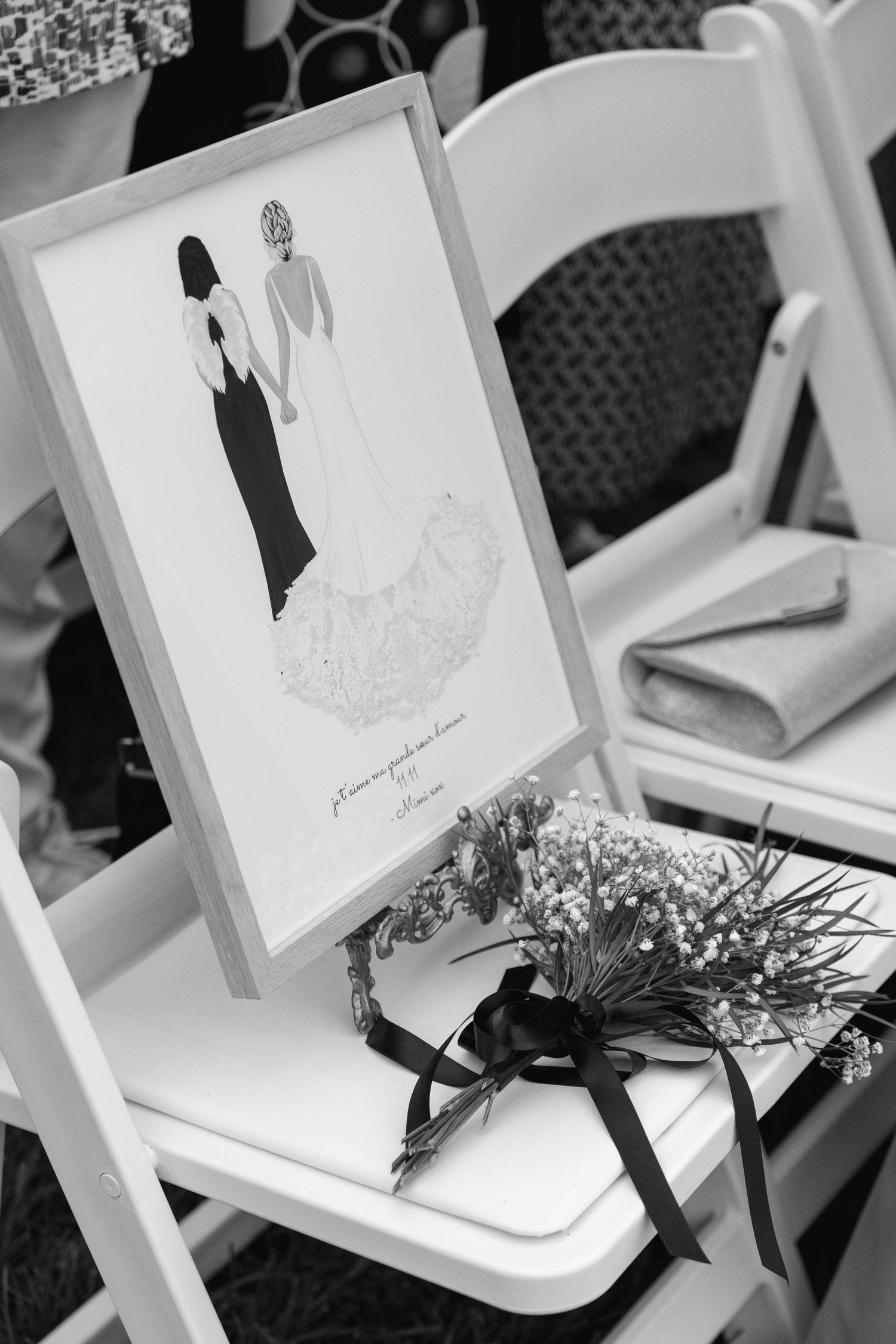 A black and white wedding program with a silhouette illustration sits on a white folding chair with small flowers.