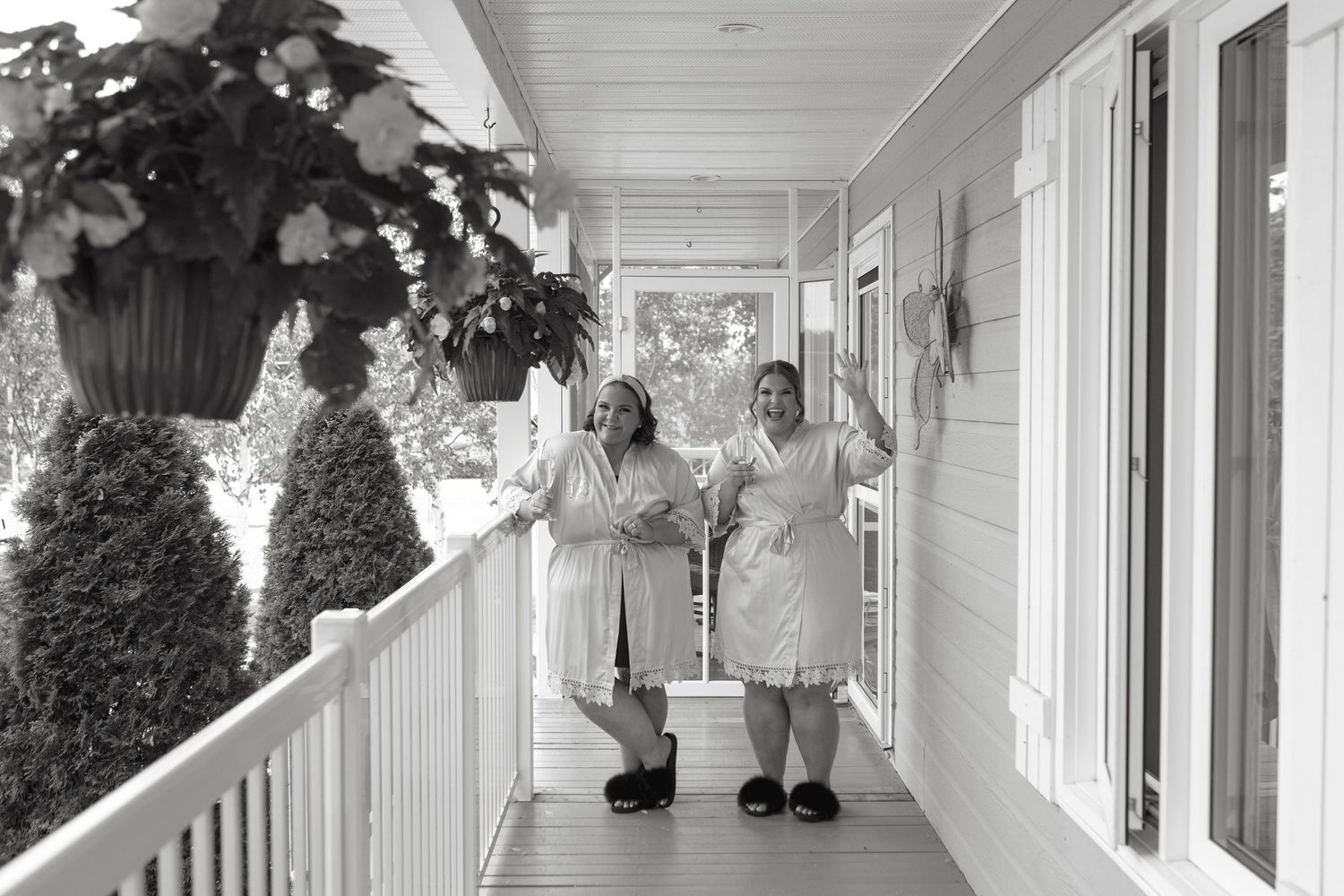 Two healthcare workers in white uniforms walk together down a covered porch walkway at a medical facility.