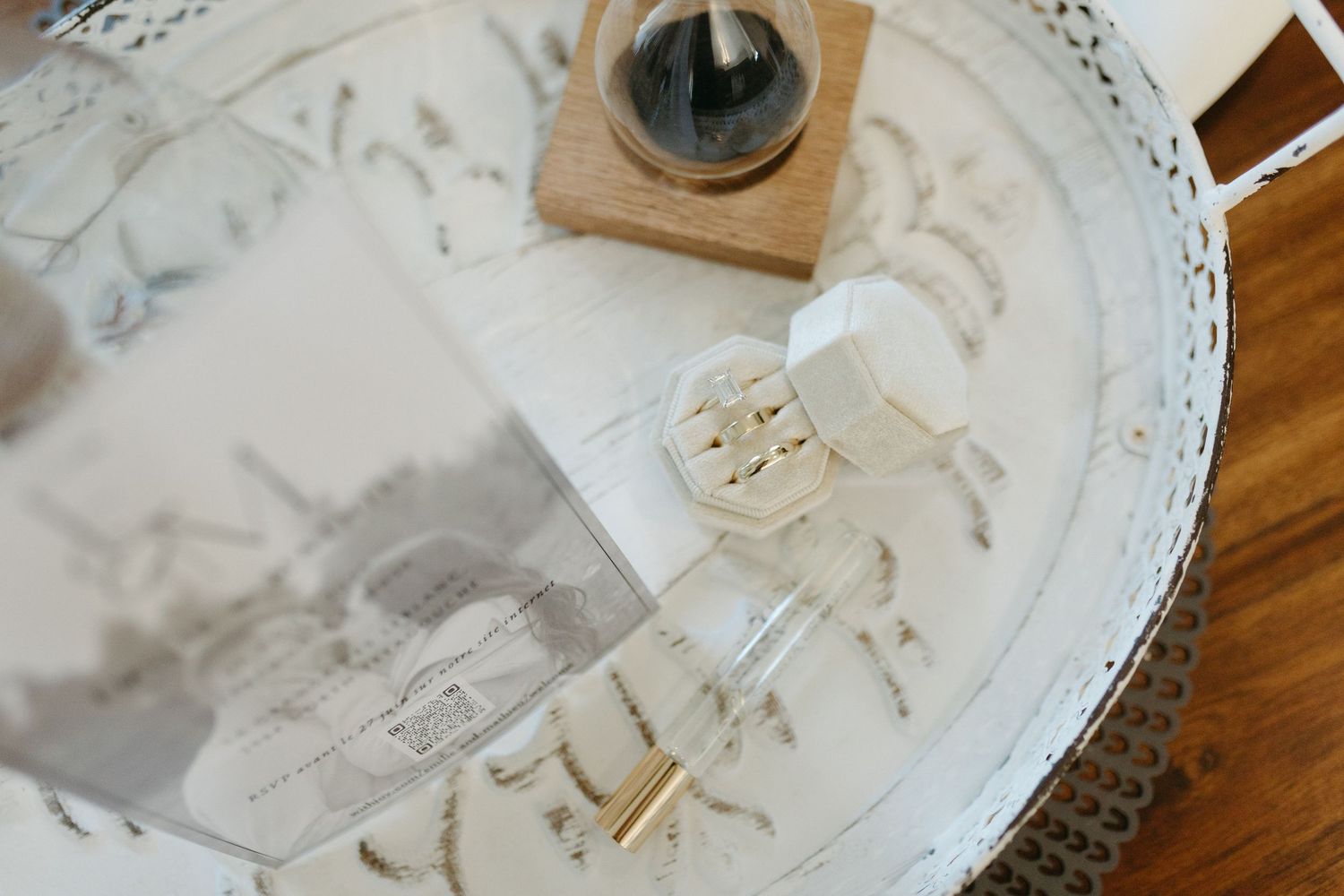A wooden coffee grinder being used to grind fresh coffee beans on a white decorative plate.