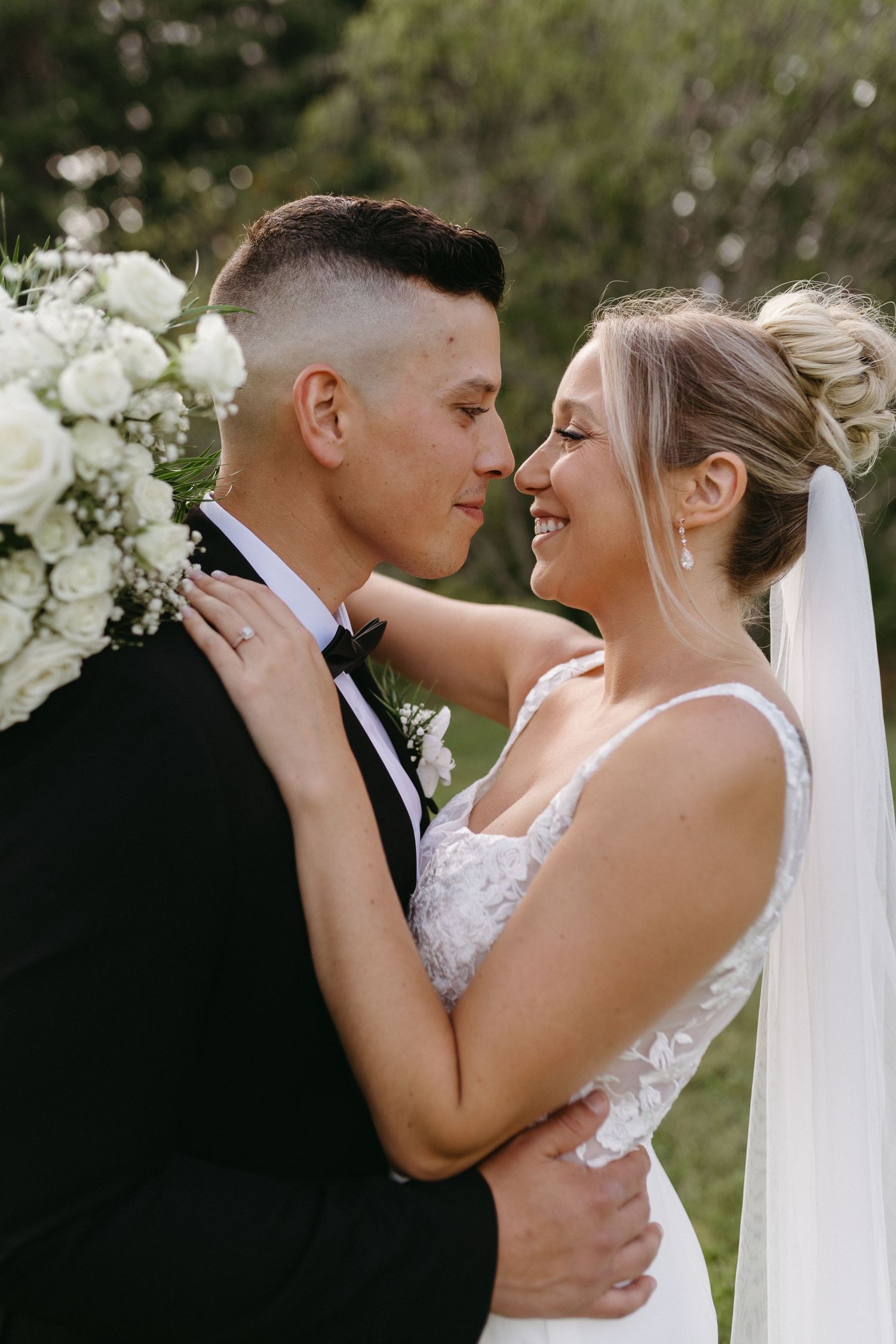 A romantic wedding couple shares intimate moments in a series of tender close-up shots outdoors.