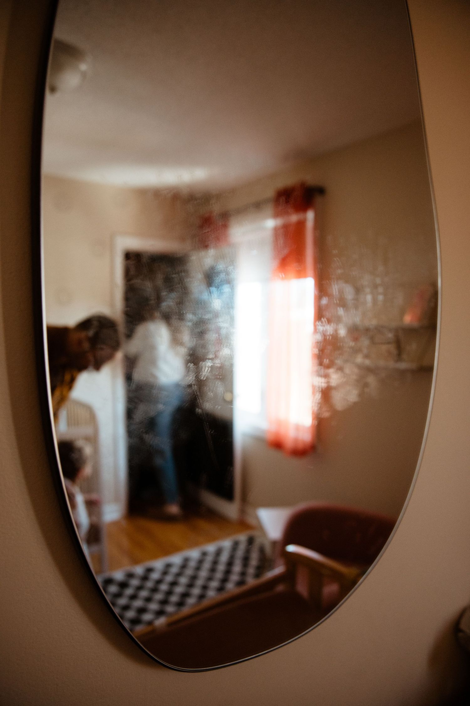Abstract blurred reflections in curved mirror showing interior room with window light.