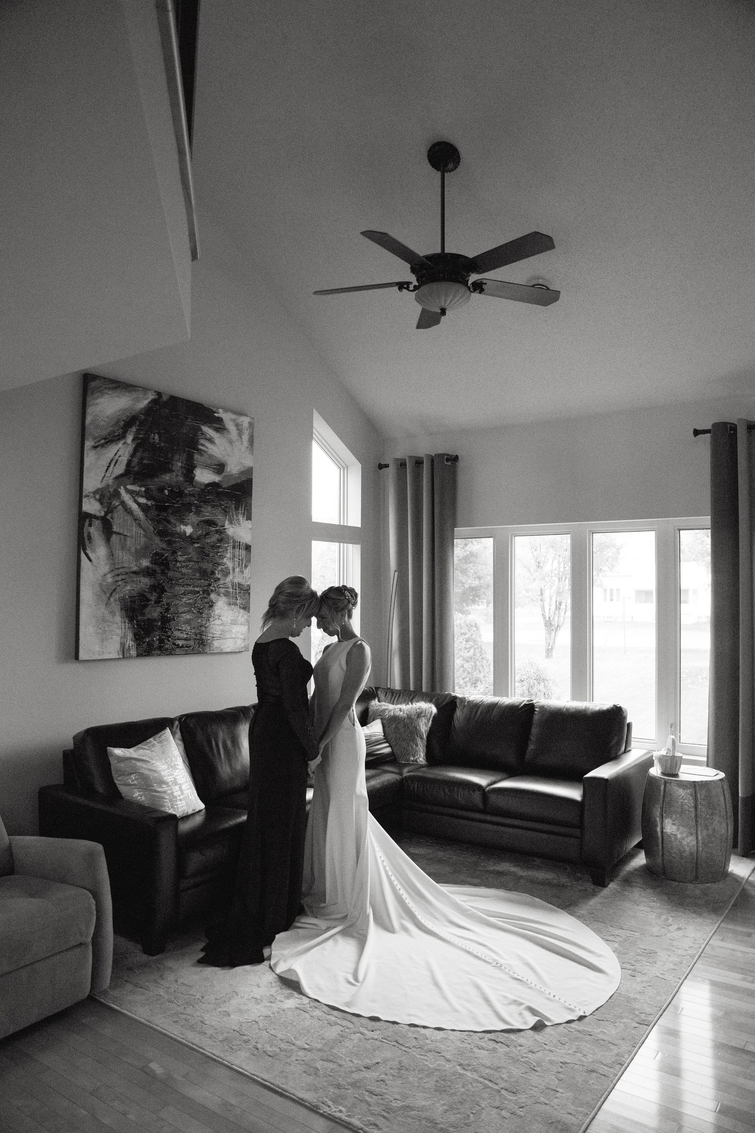 A black and white photo series showing a flowing white wedding dress in an empty room with natural light streaming in.