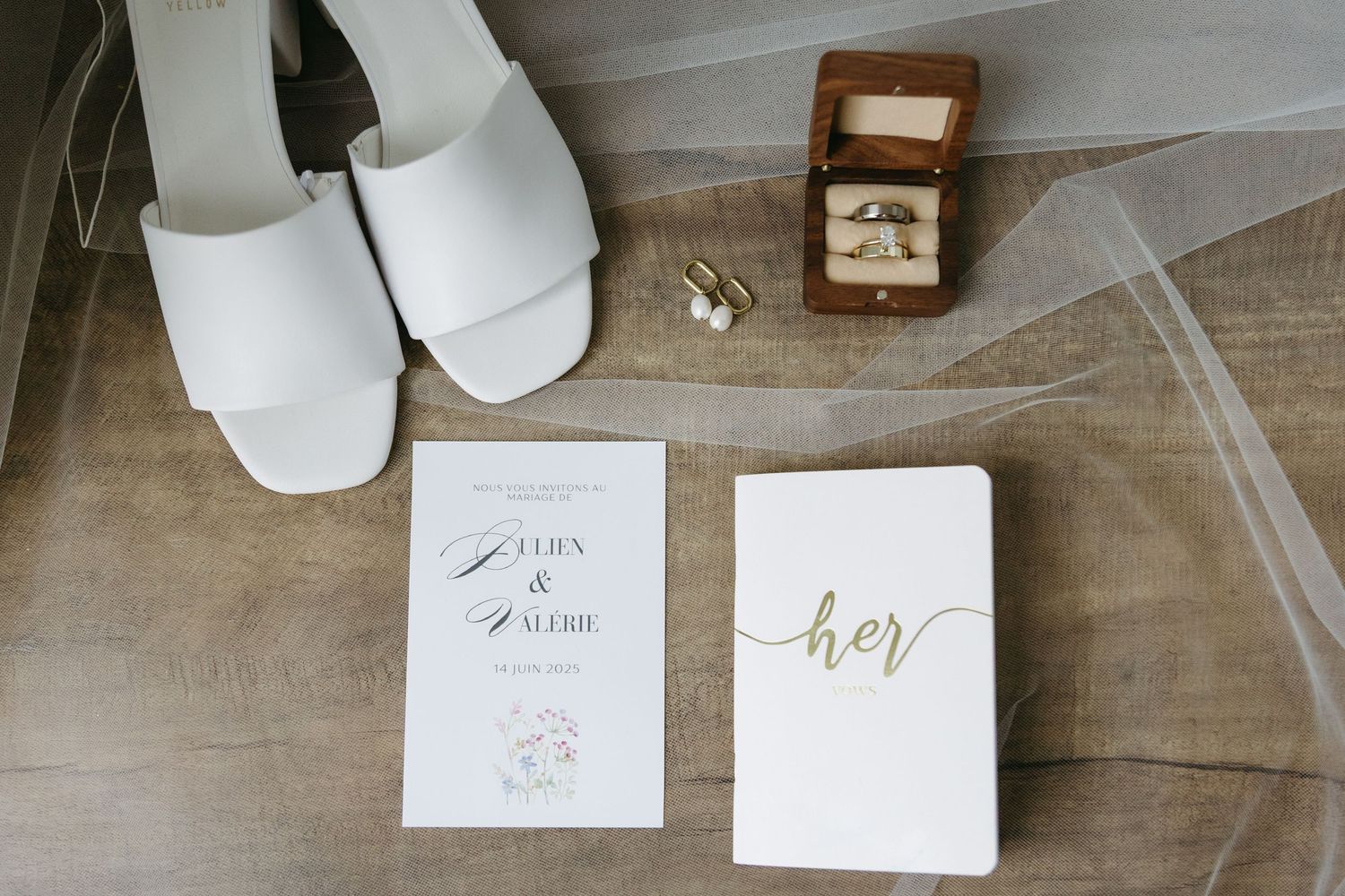 White wedding reception table settings with place cards and elegant decor arranged in a rustic venue.