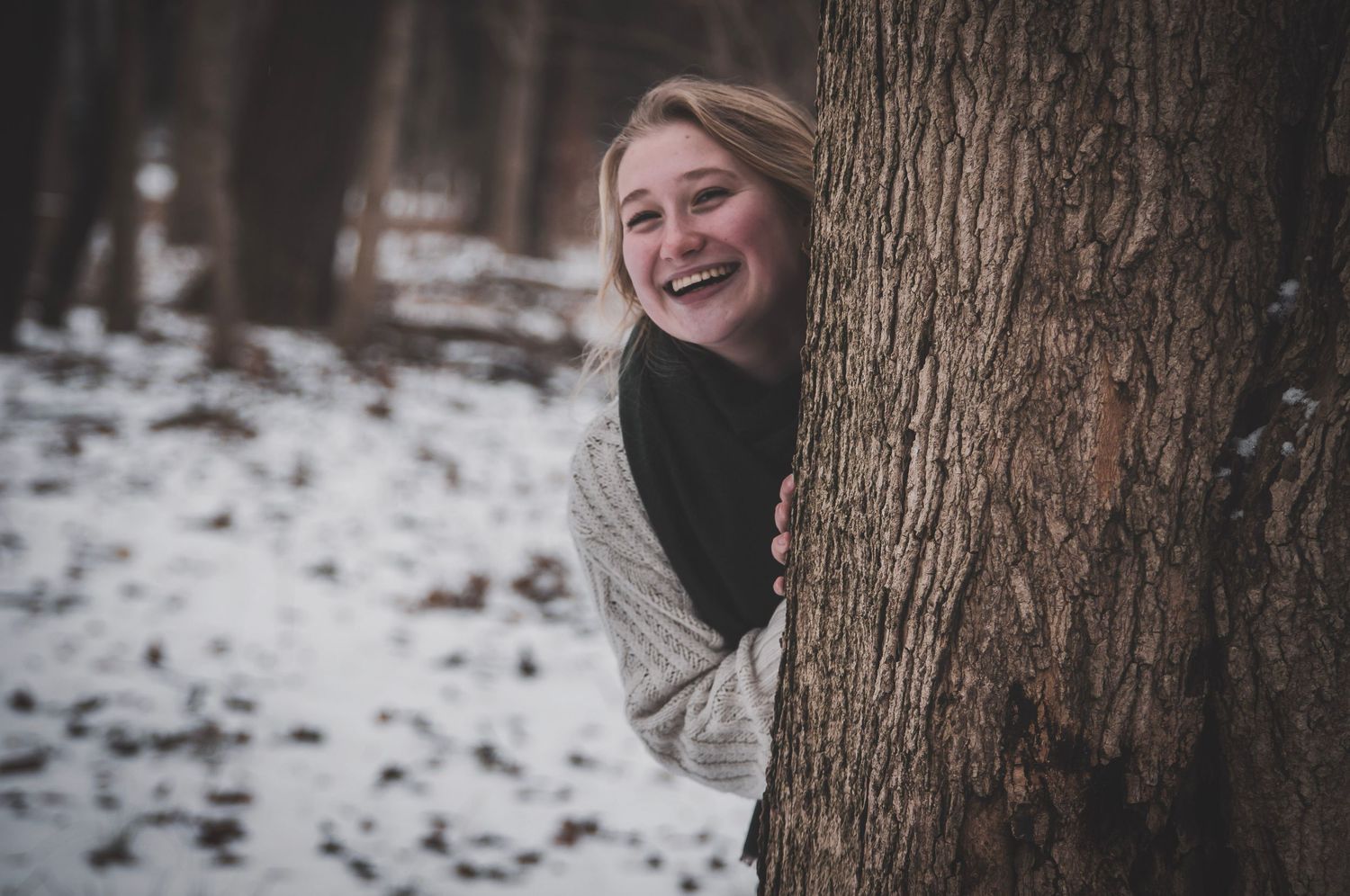 Outdoor portrait in the snowy woods capturing gentle candid smiles