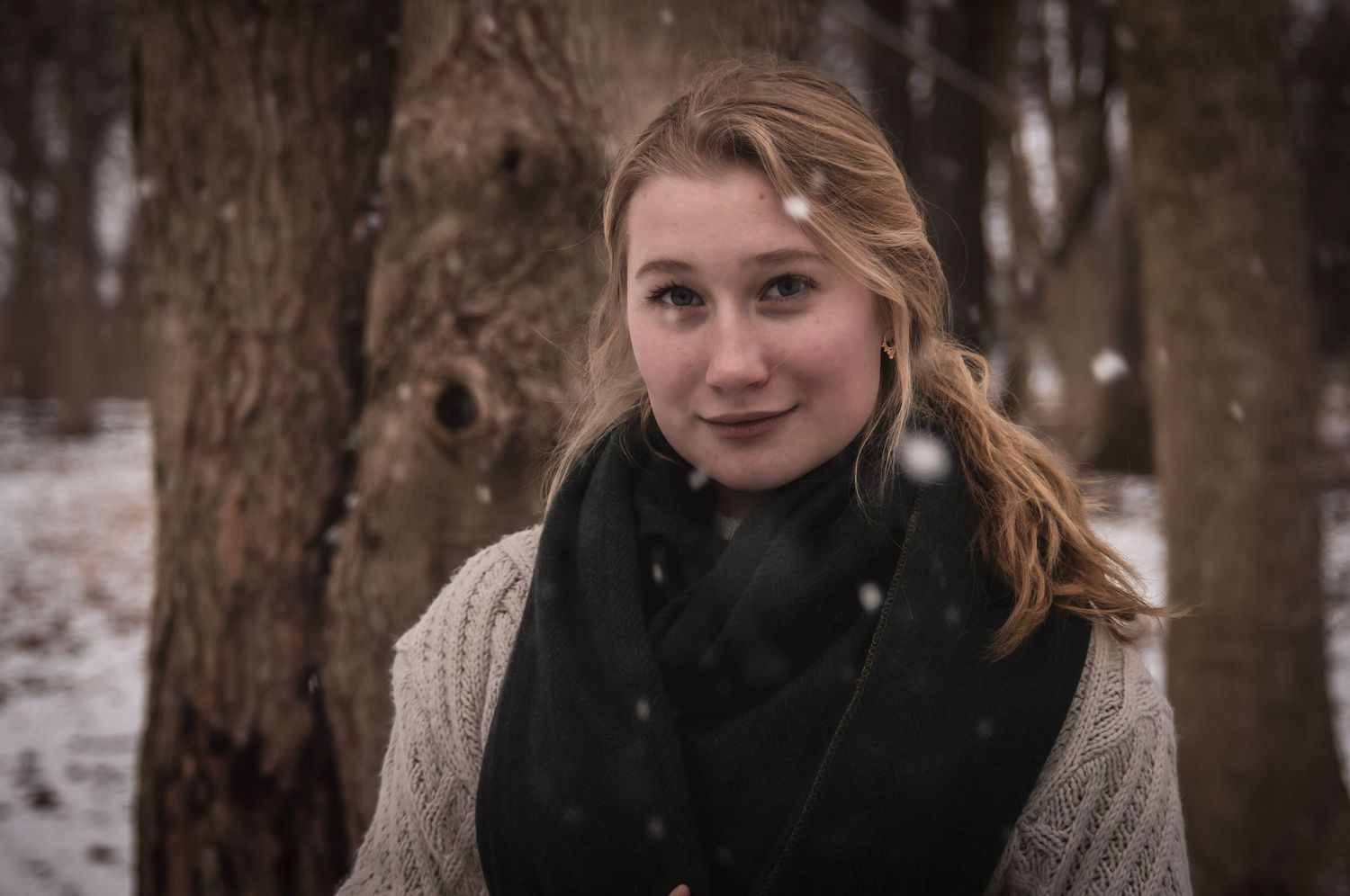 Outdoor portrait in the snowy woods capturing candid emotions and soft smiles