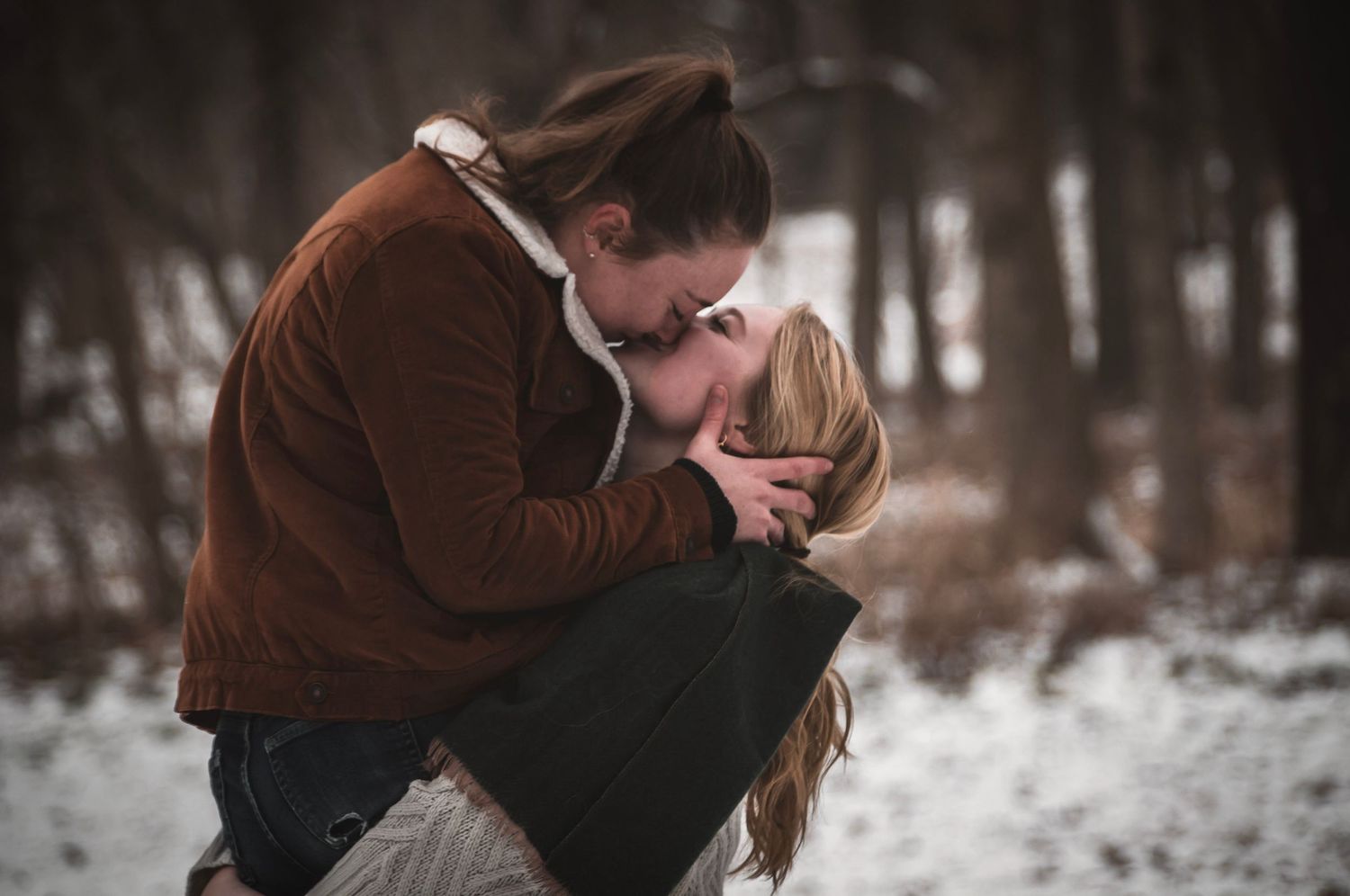 Queer couple holding hands while hiking in Colorado during an engagement session by Shay Godfrey