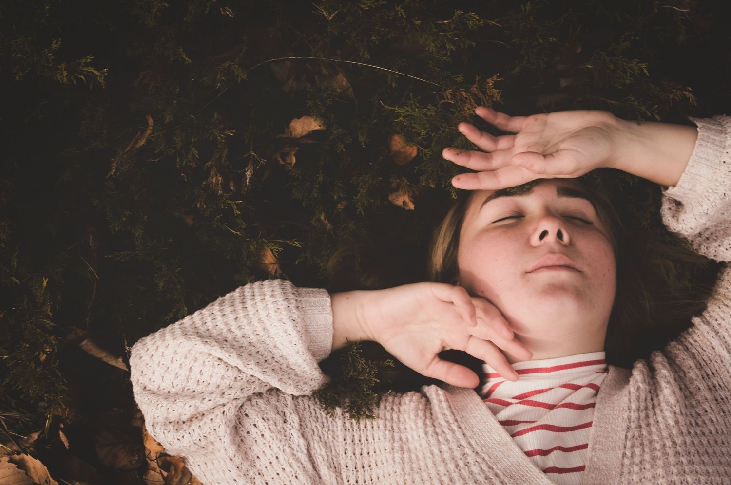 Person laying on the ground posing in the beautiful fallen leaves