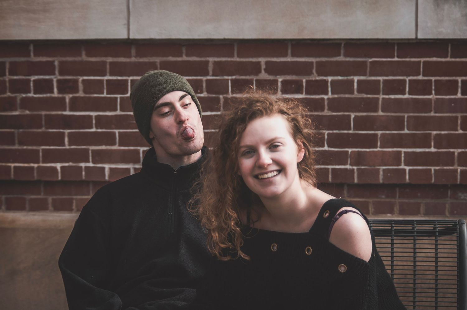 Couple being silly sticking their tongues out at each other with joyful expressions