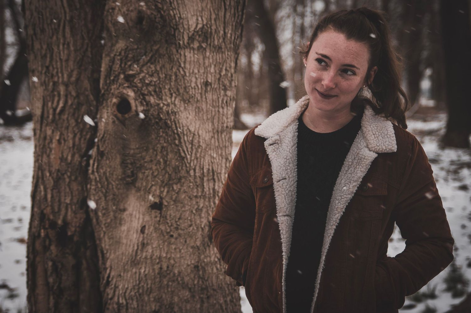 Outdoor portrait in the snowy woods capturing gentle candid smiles