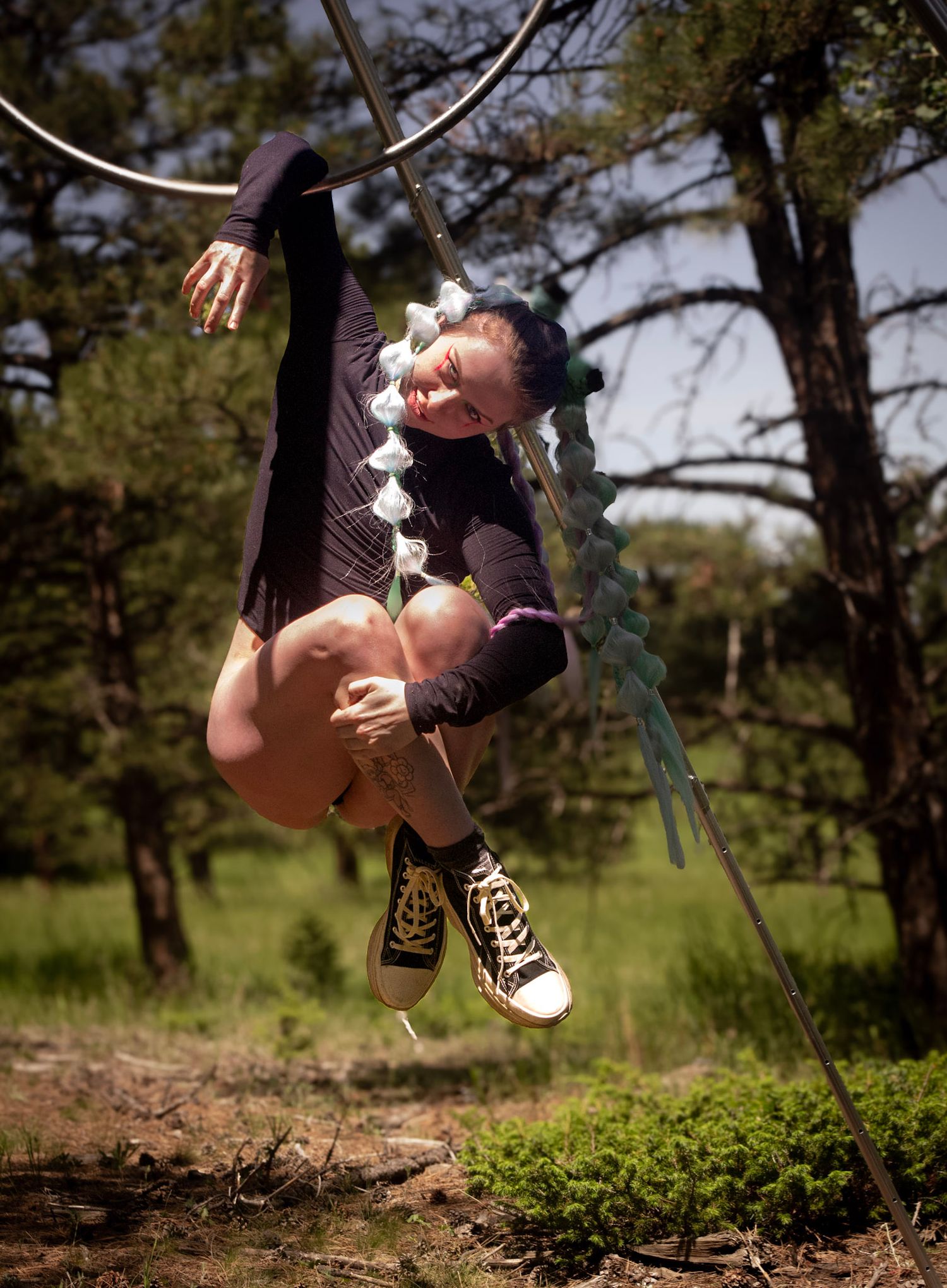 Shay Godfrey photographing an aerial performance on the Lyra in a forested Colorado setting