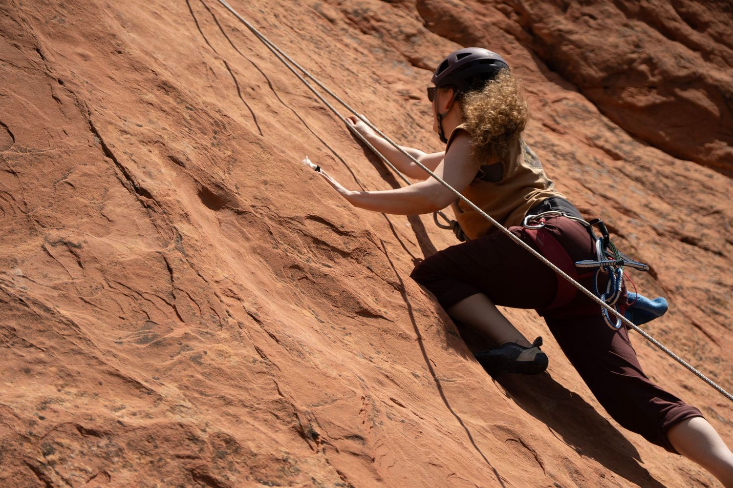 Shay Godfrey photographing a climber scaling a Colorado rock face during an adventure session