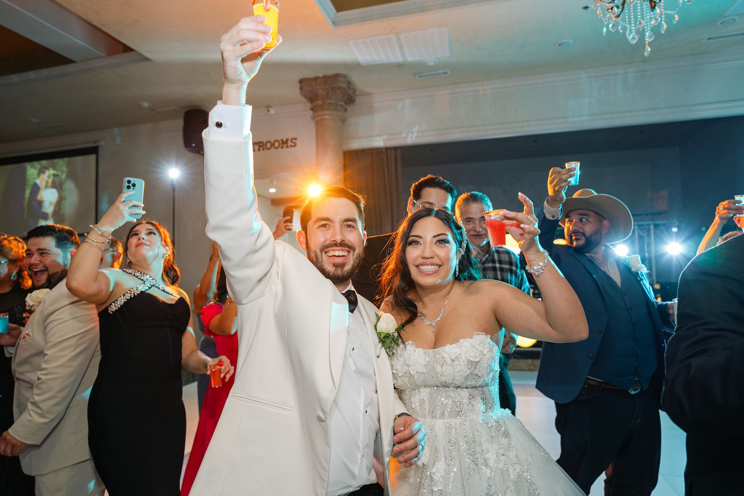 Wedding reception party scenes with dancing guests and chandelier lighting.