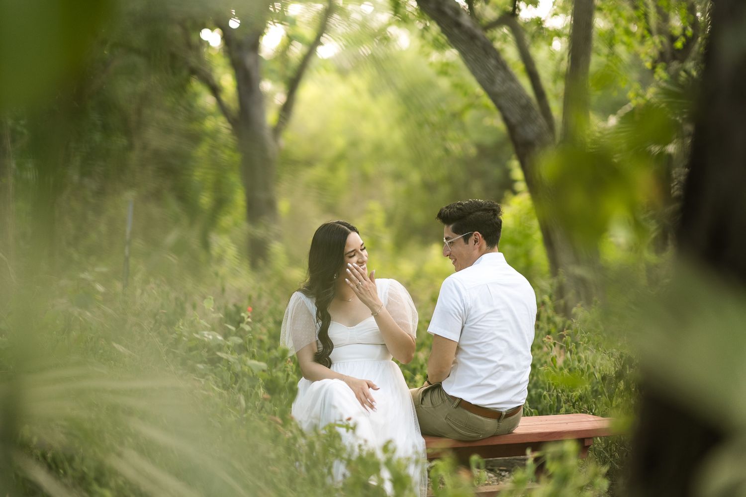 Candid moments of couple walking through lush garden pathway.