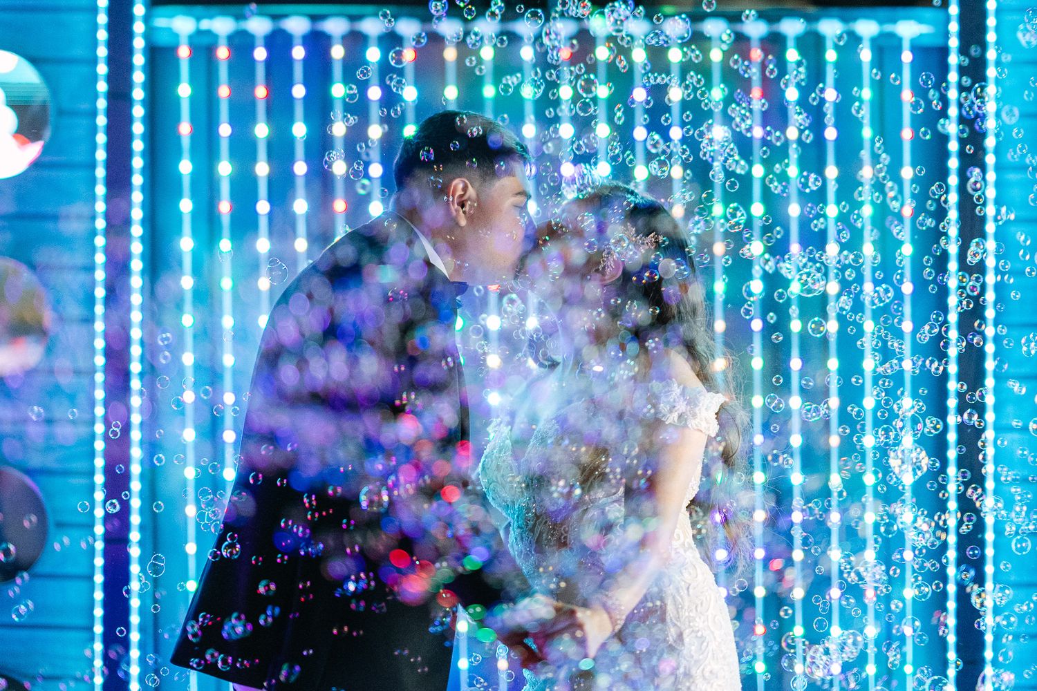 Wedding celebration with blue LED light curtain creating magical atmosphere.