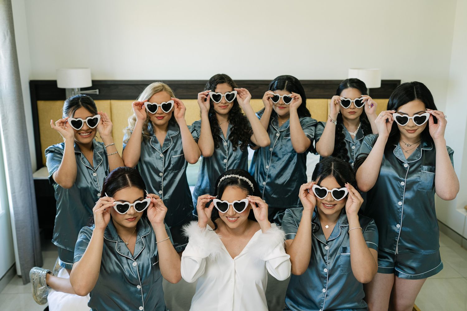 Group wearing matching outfits and sunglasses posing together in a line.