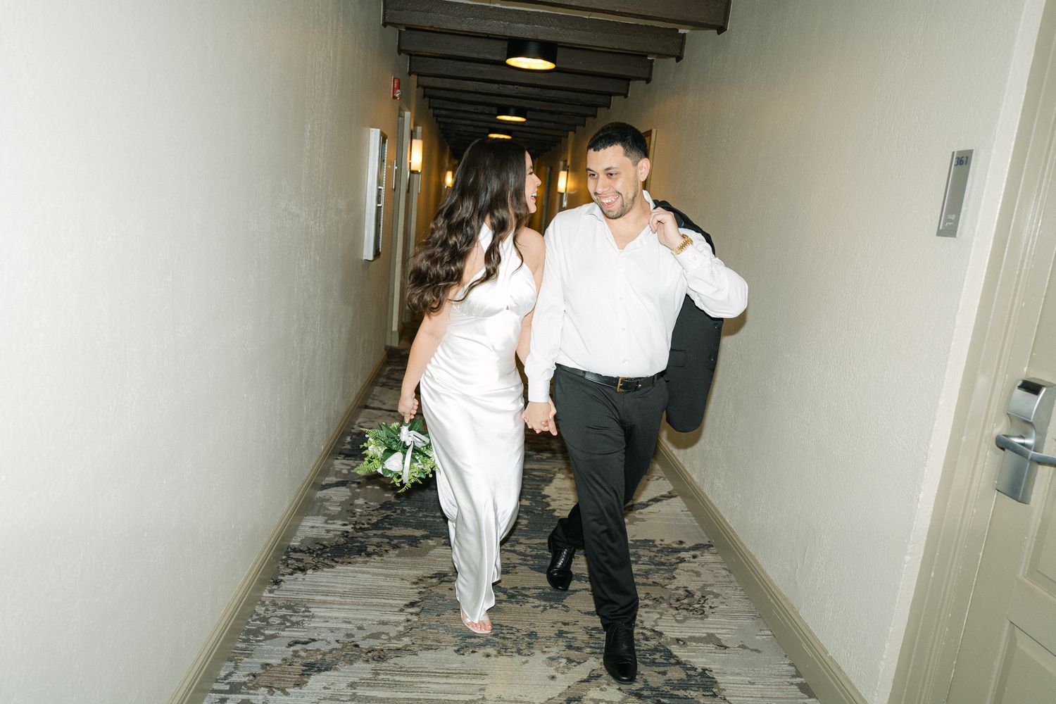 People walking through a modern hallway with carpeted floors.