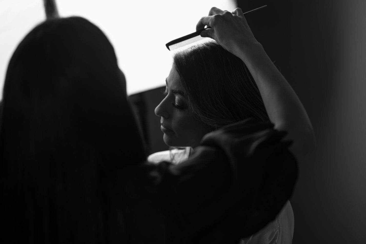 Dramatic black and white silhouettes of wedding day preparation.