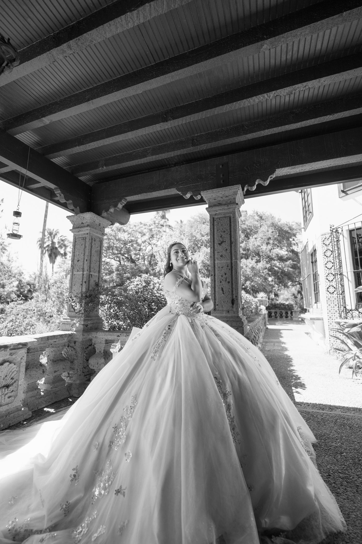 Collection of black and white photos showing flowing ballgown dress under covered outdoor area.