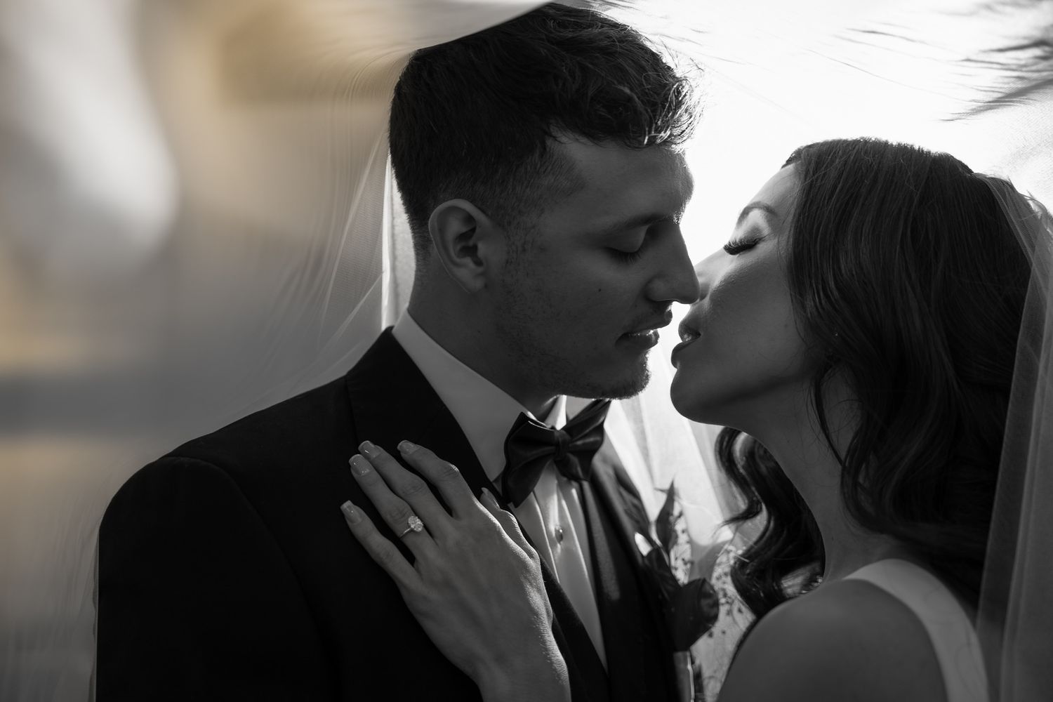 Intimate black and white portrait of newlyweds sharing romantic moment.