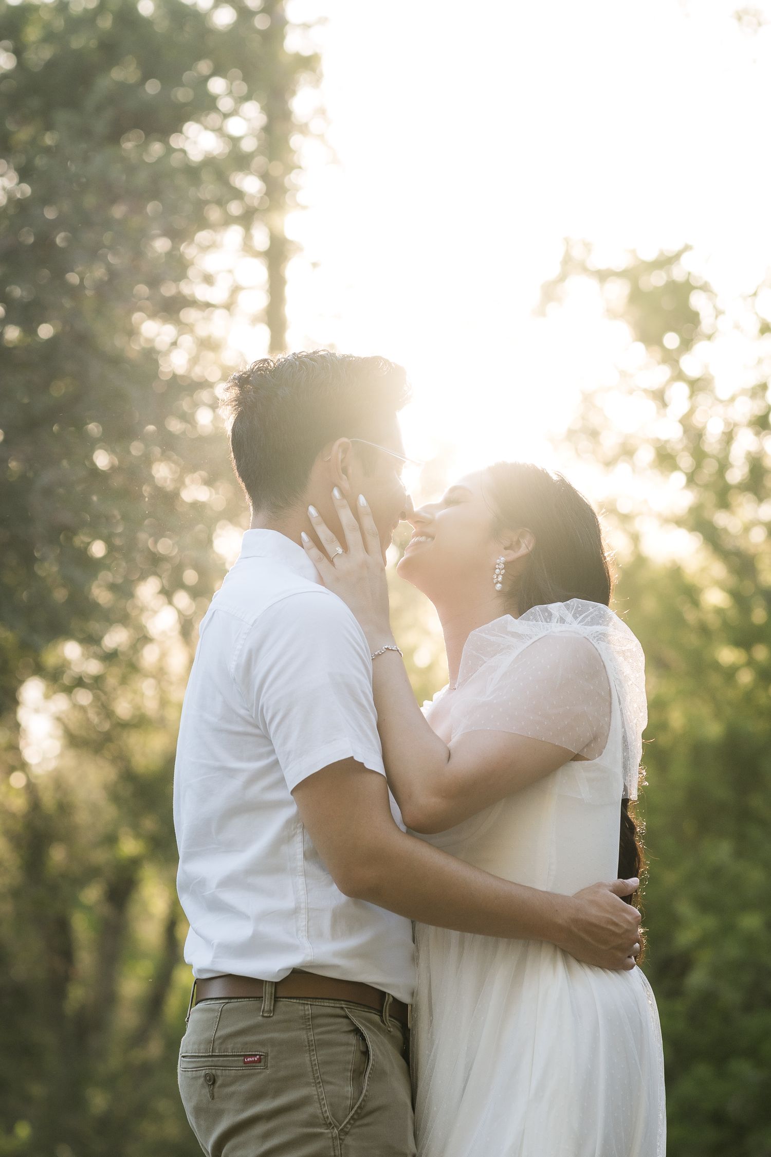 Sunset embrace in an outdoor garden setting with golden backlight.