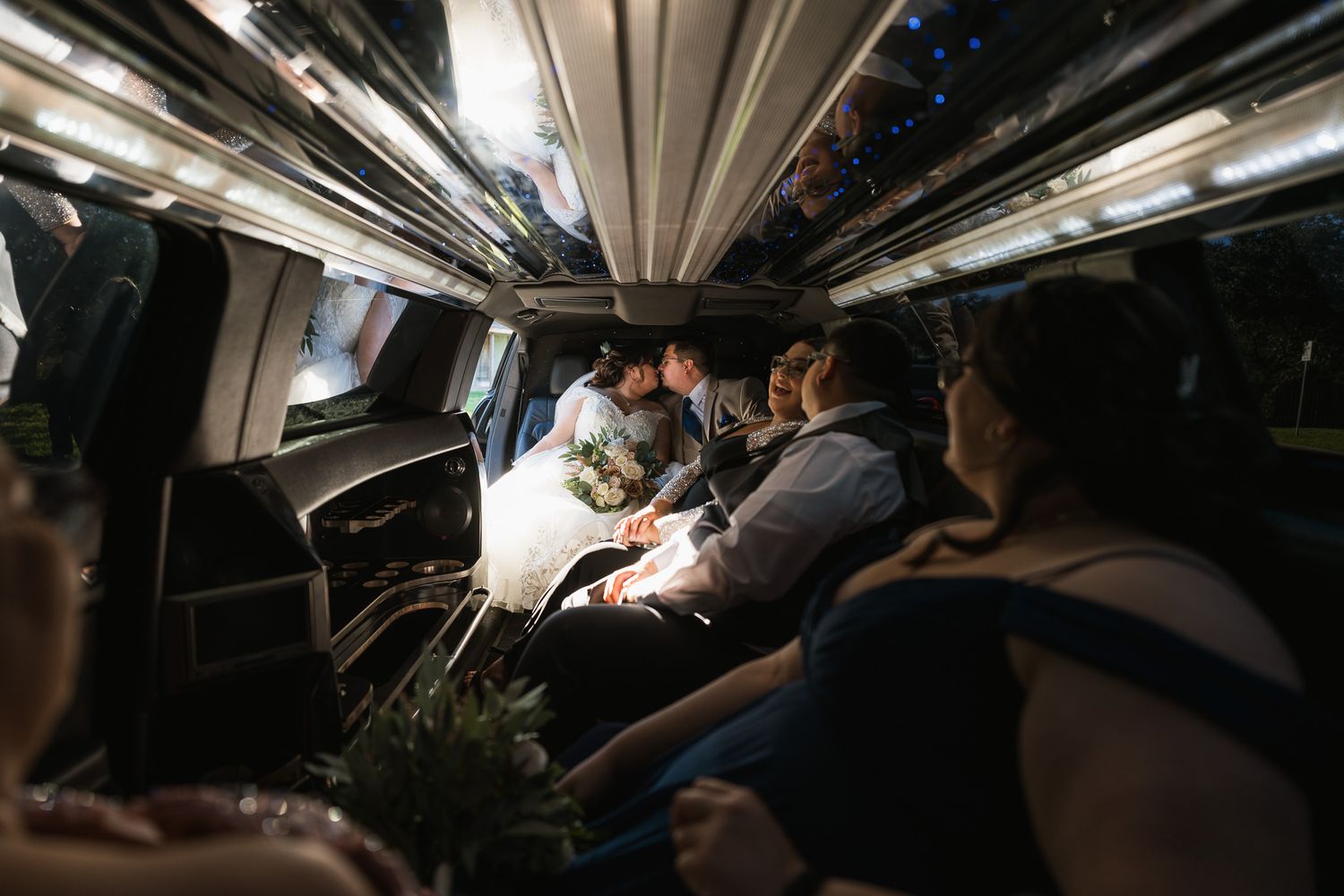 Interior view of a dimly lit luxury transportation vehicle with passengers inside.