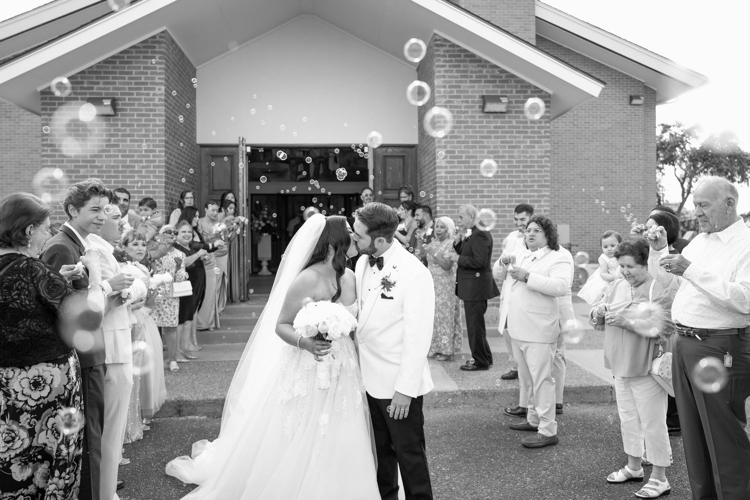 Wedding guests enjoying a celebration outdoors with floating bubbles creating a magical atmosphere.